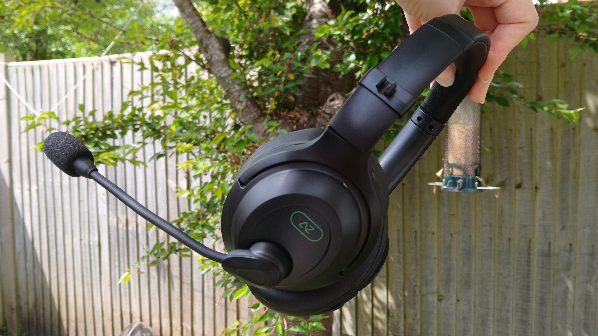 An AceZone A-Blaze wireless gaming headset held up outside.