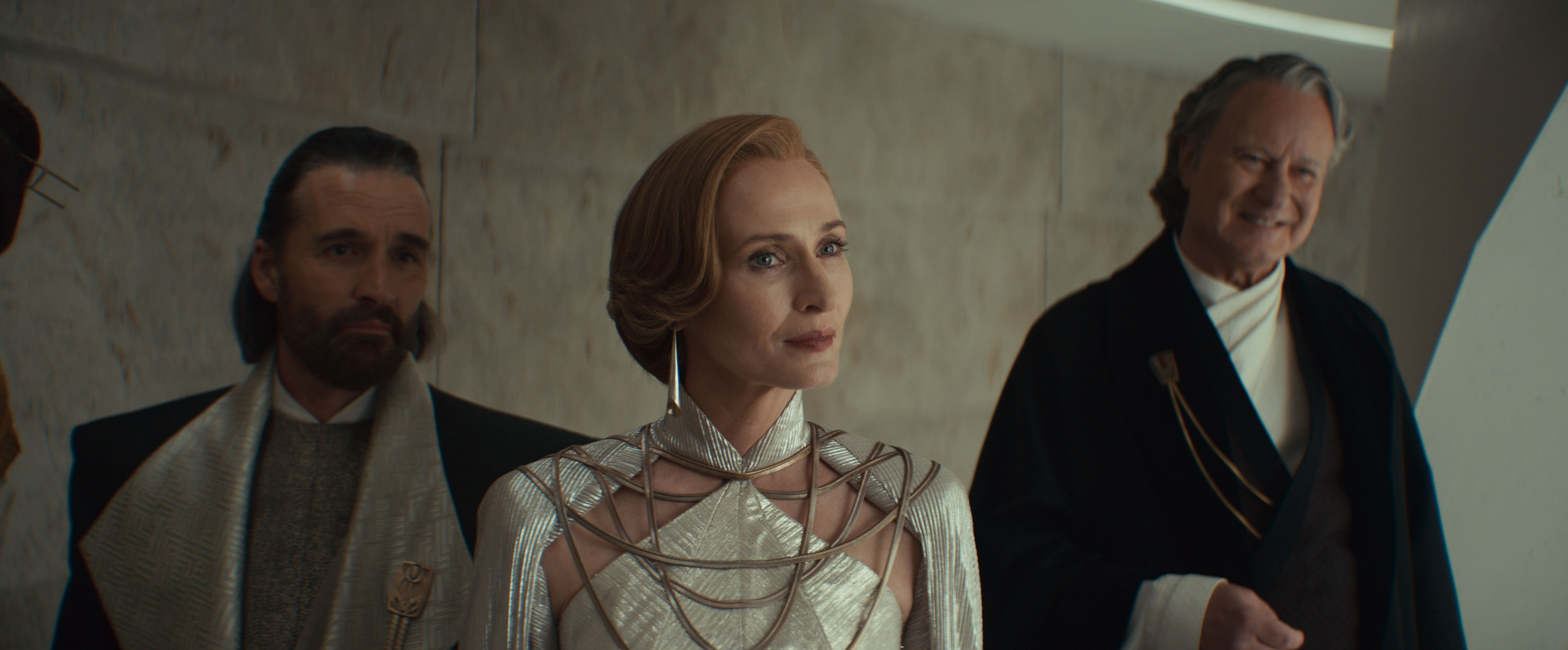 Mon Mothma, her husband, and Luthen, listening at the party in a still from Andor season 2 episode 6 Mon Mothma, her husband, and Luthen, listening at the party in a still from Andor season 2 episode 6