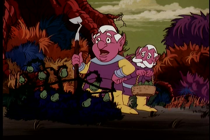 Two of the Trobbits, dwarf-like fantasy creatures with bright magenta skin and white hair, wearing purple tunics and yellow stockings, stand together in front of a bramble patch in a scene from Blackstar