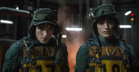 Mickey 18 and Mickey 17 (both played by Robert Pattinson) standing next to one another in Mickey 17.