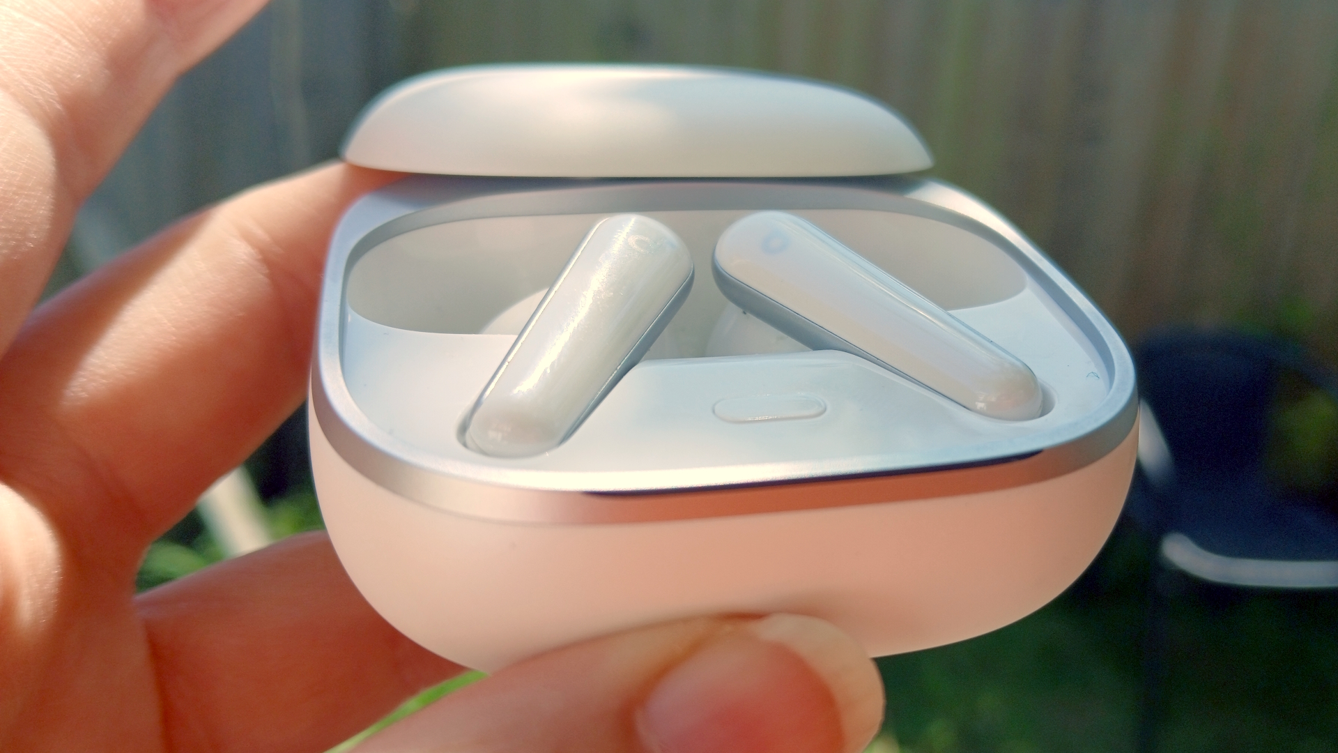 The Soundcore Liberty 5 earbuds outside in the sunlight and held by our reviewer, Katie Wickens.