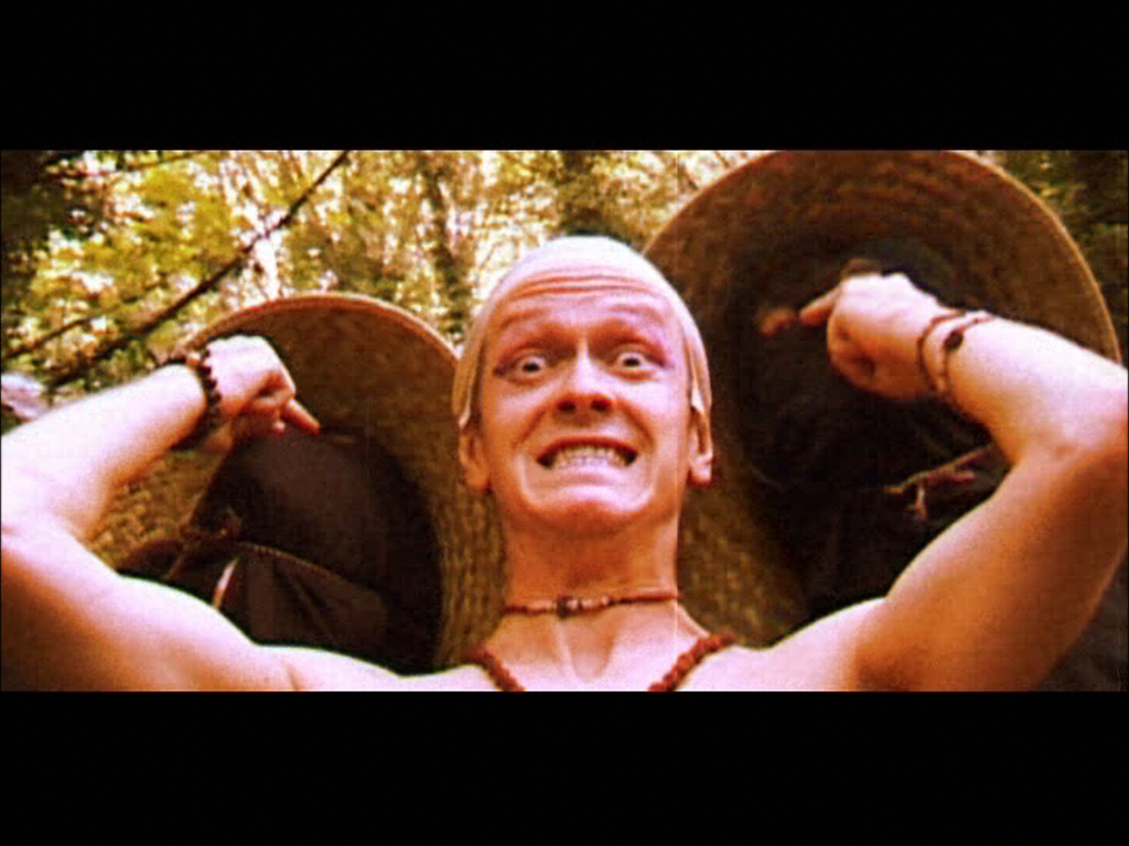 A man grimacing as he pokes two ninjas behind him in the eyes in Rag Doll Kung Fu.