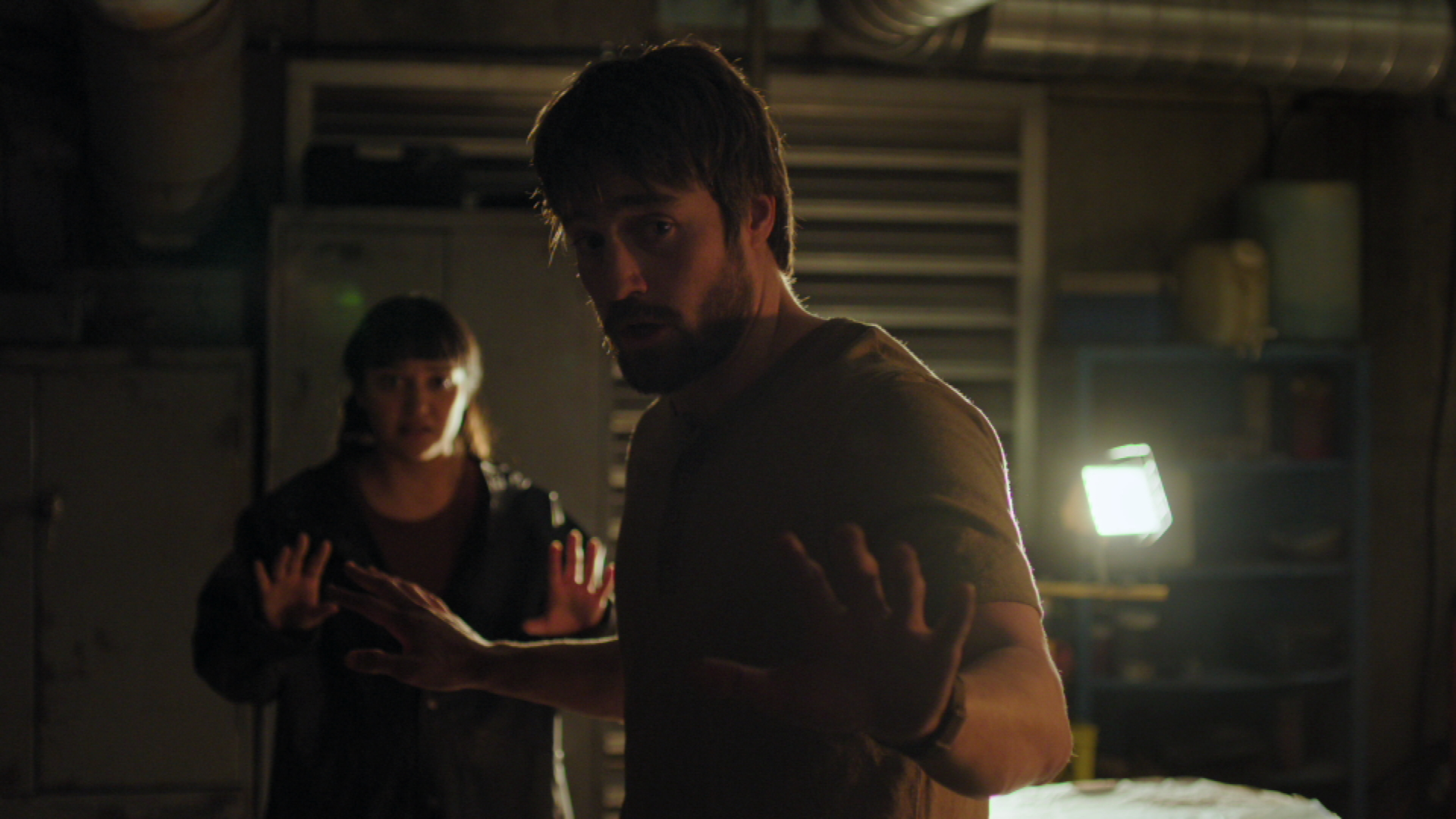 Owen and Mel from The Last of Us show hold their hands up as Ellie threatens them from off-camera. Owen and Mel from The Last of Us show hold their hands up as Ellie threatens them from off-camera.