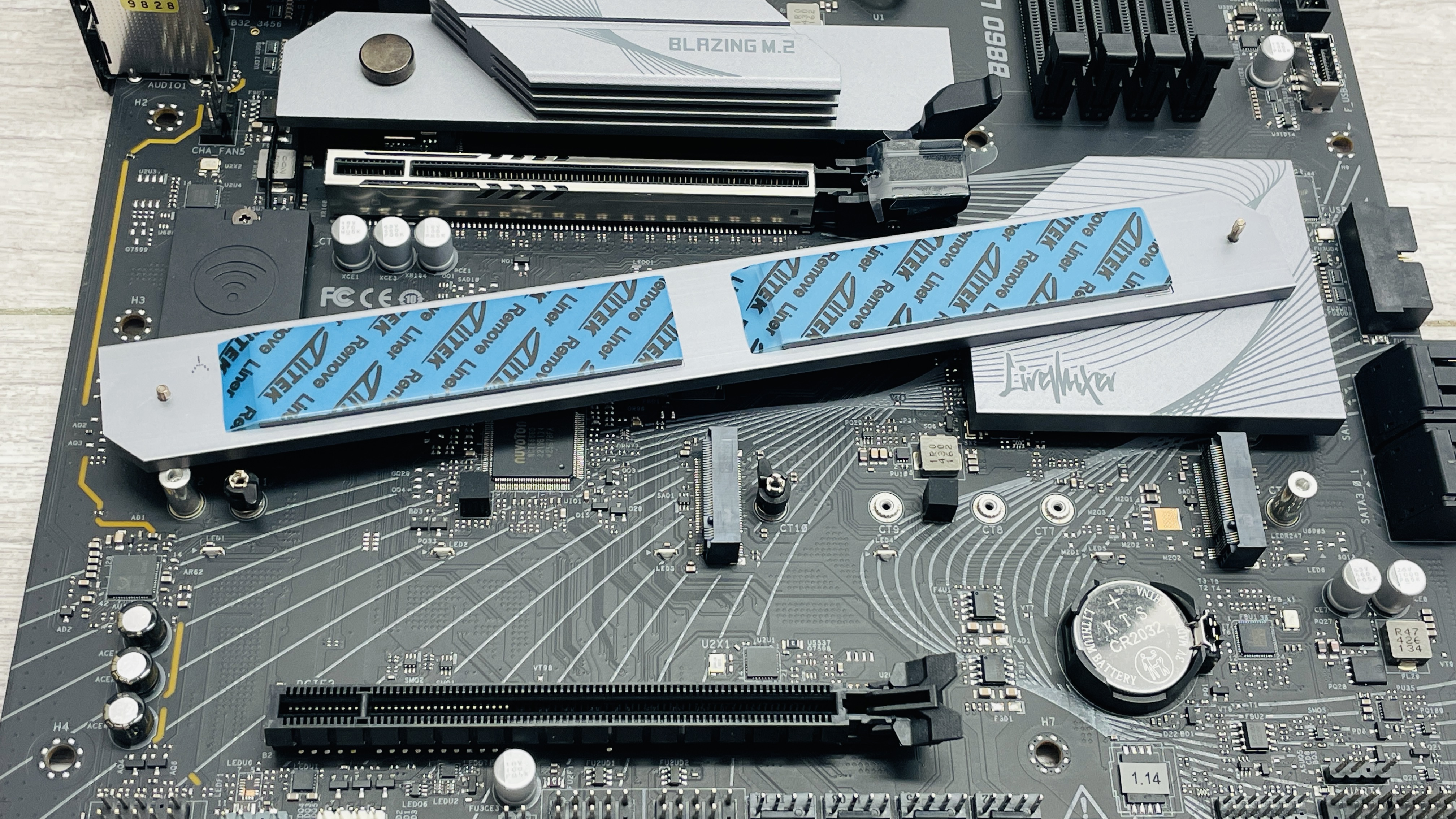 An ASRock B860 LiveMixer Wi-Fi motherboard on a desk.