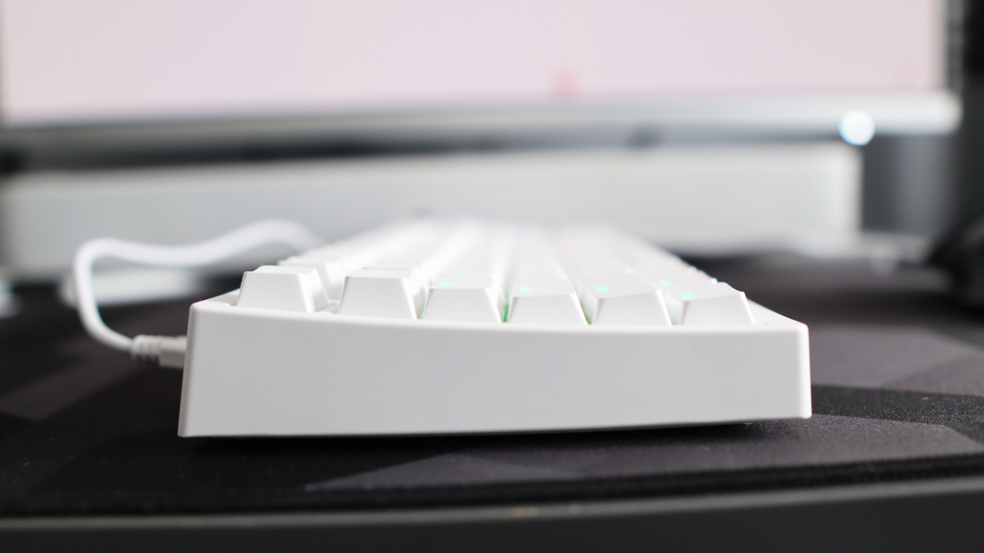 A Gamakay TK75HE gaming keyboard in white on a black and grey mouse pad with RGB lighting enabled.