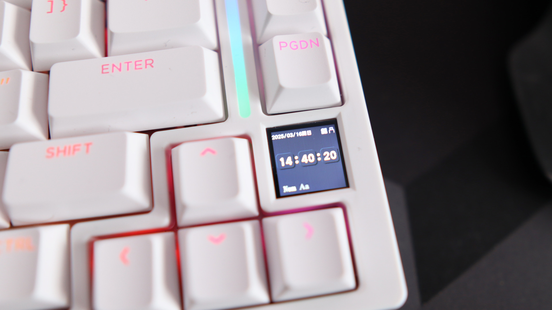 A Gamakay TK75HE gaming keyboard in white on a black and grey mouse pad with RGB lighting enabled.