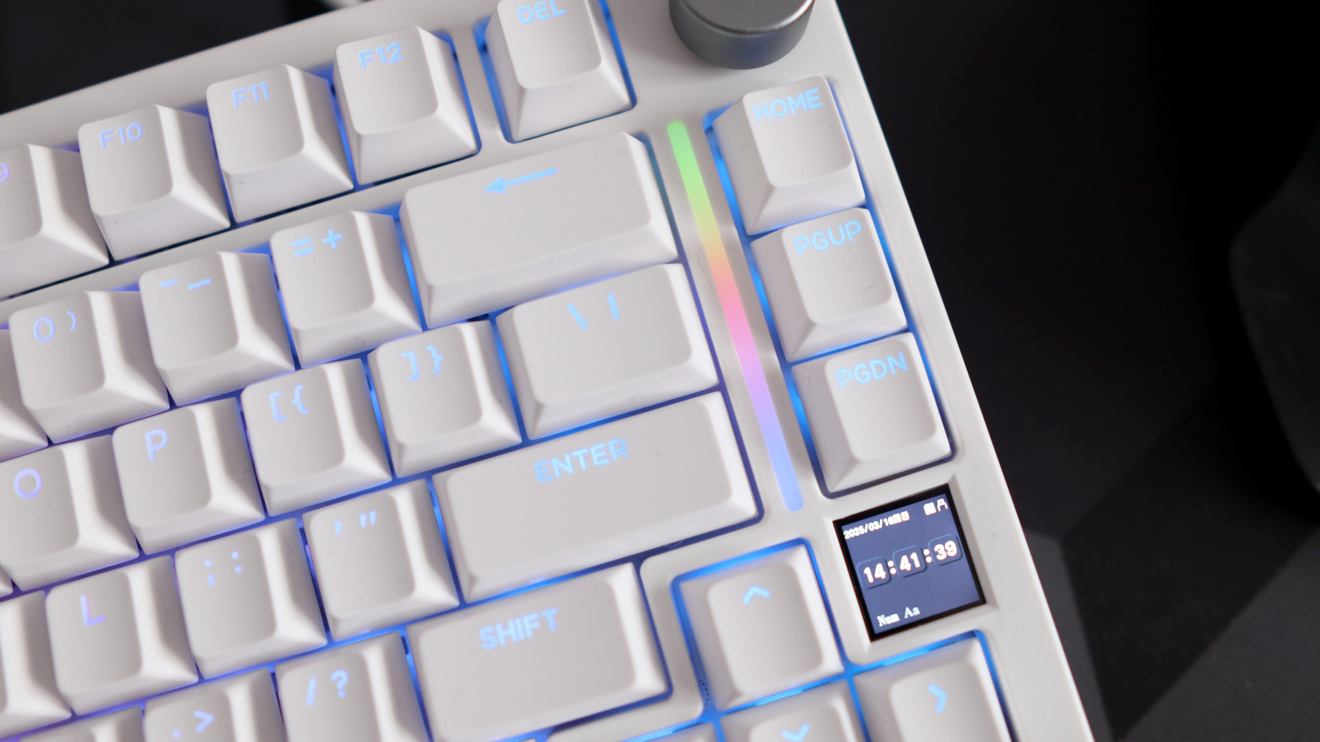 A Gamakay TK75HE gaming keyboard in white on a black and grey mouse pad with RGB lighting enabled.