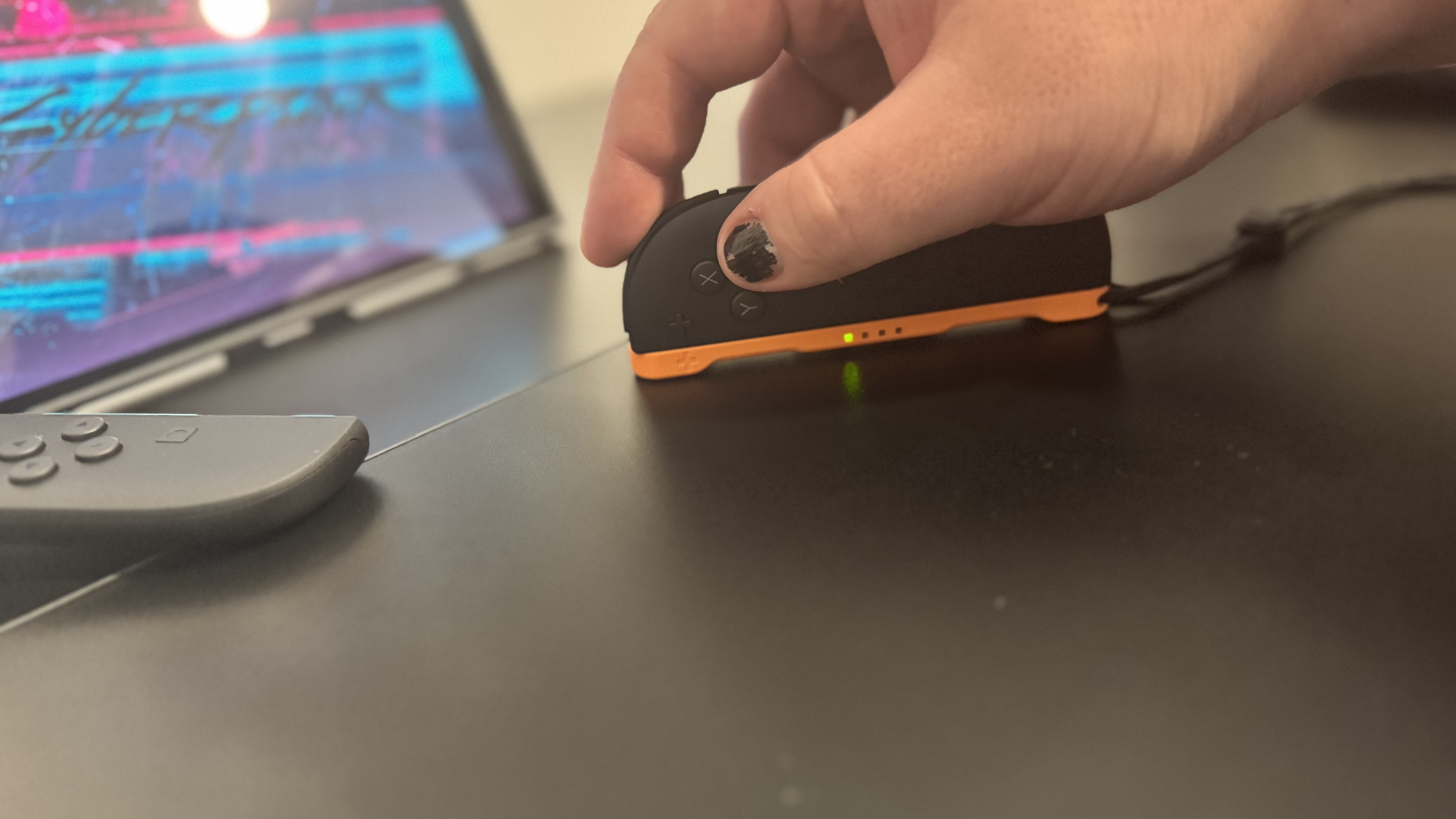 A picture of a Nintendo Switch 2, in mouse mode, with Cyberpunk 2077 in the background
