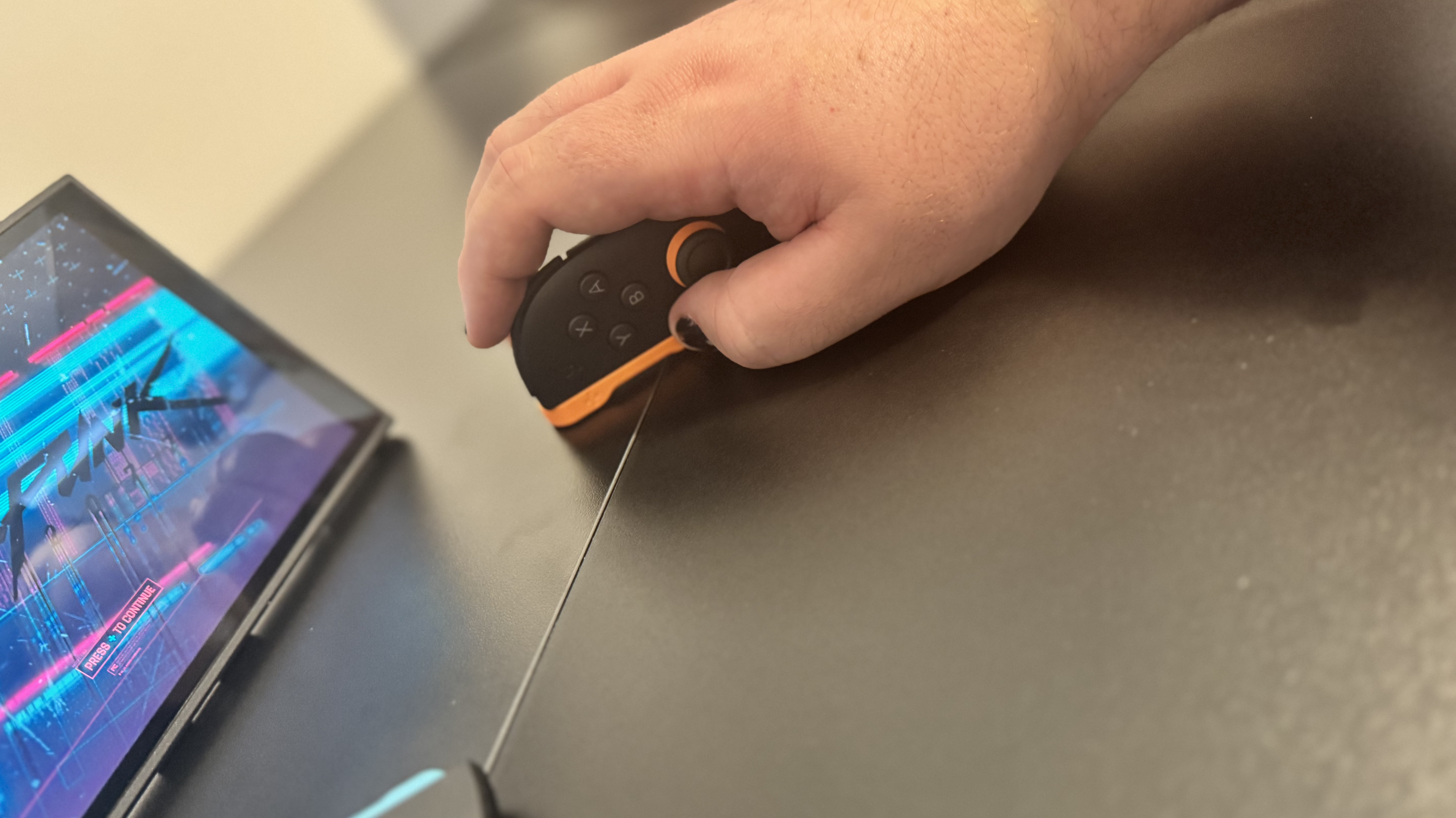 A picture of a Nintendo Switch 2, in mouse mode, with Cyberpunk 2077 in the background
