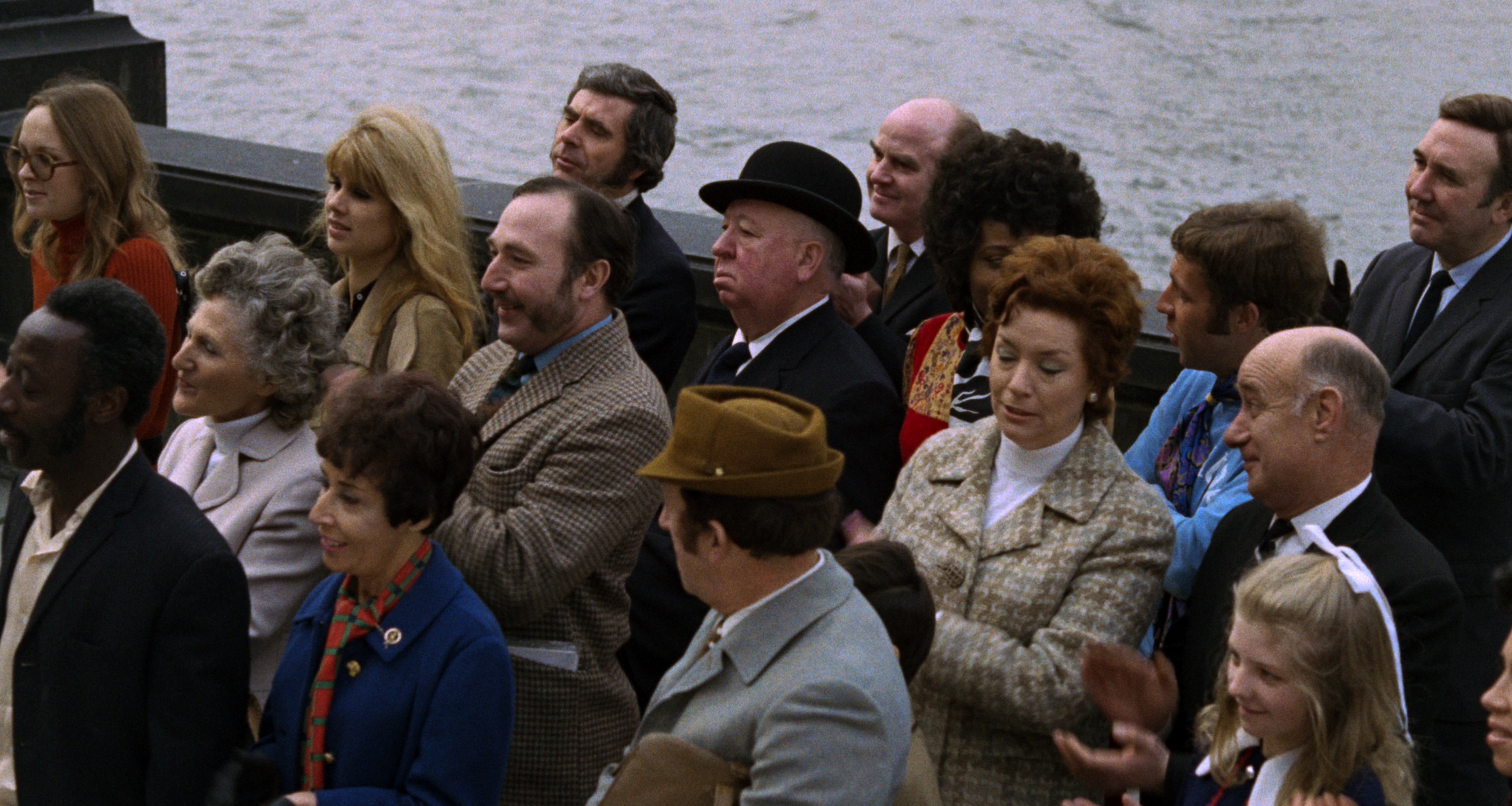 A crowd of people stand on a pier in Frenzy
