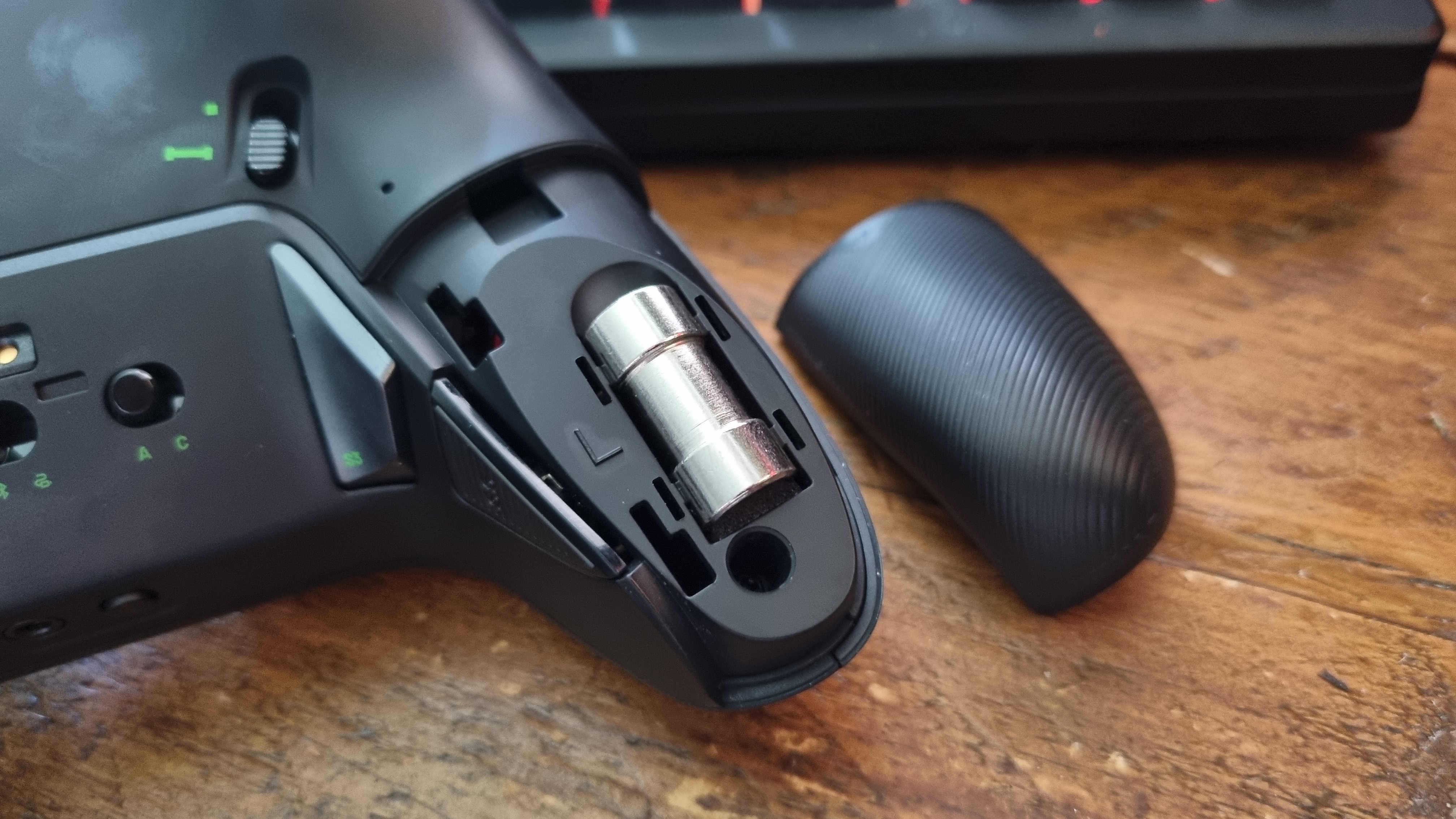The Nacon Revolution X Unlimited with its rear grip cover removed, with a weight placed inside