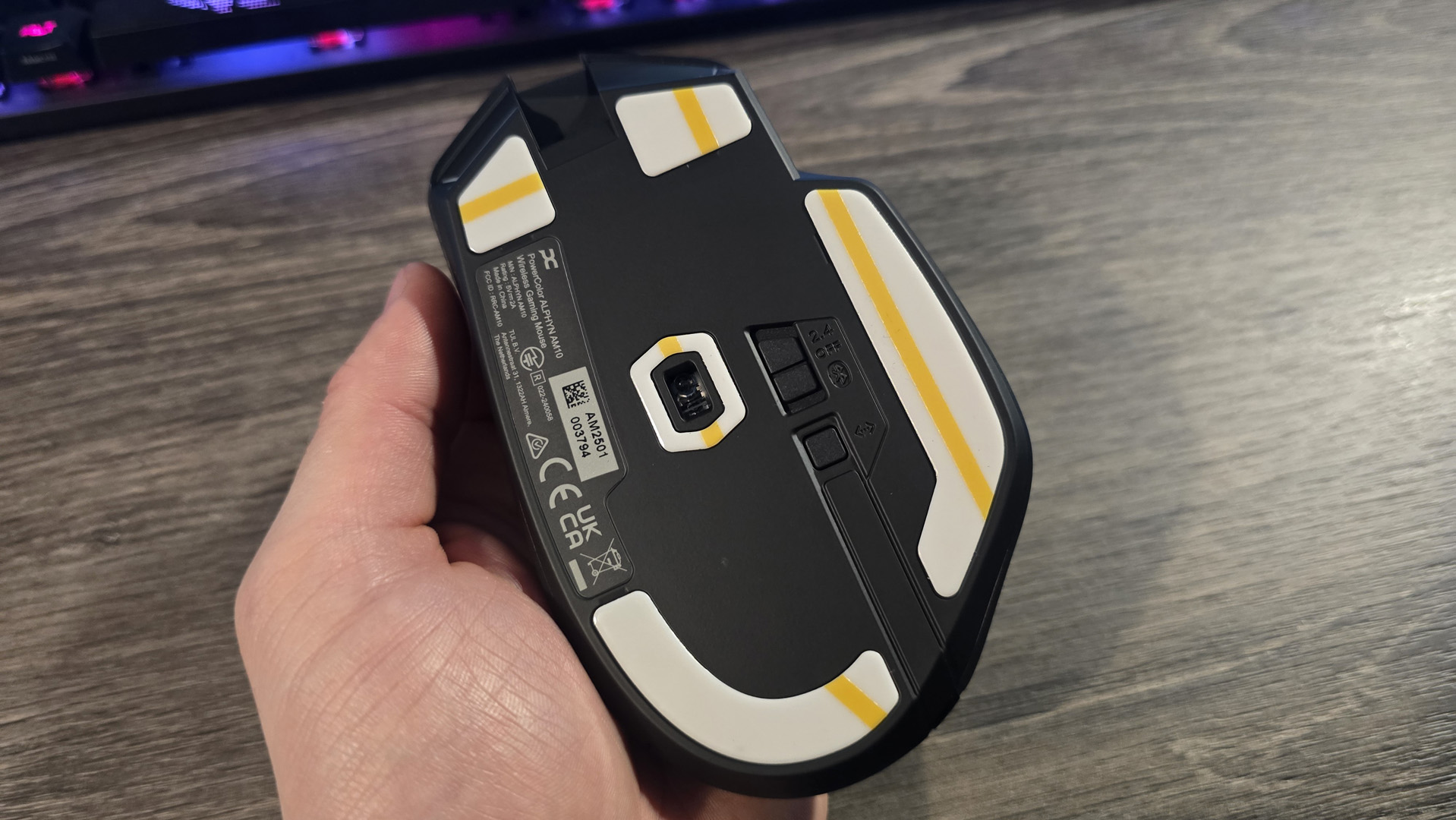 Powercolor Alphyn AM10 Wireless Gaming Mouse with RGB enabled on a desk.