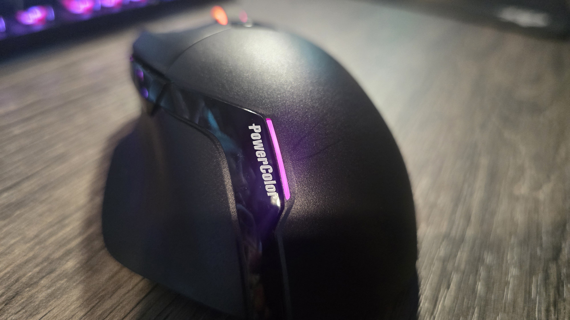 Powercolor Alphyn AM10 Wireless Gaming Mouse with RGB enabled on a desk.