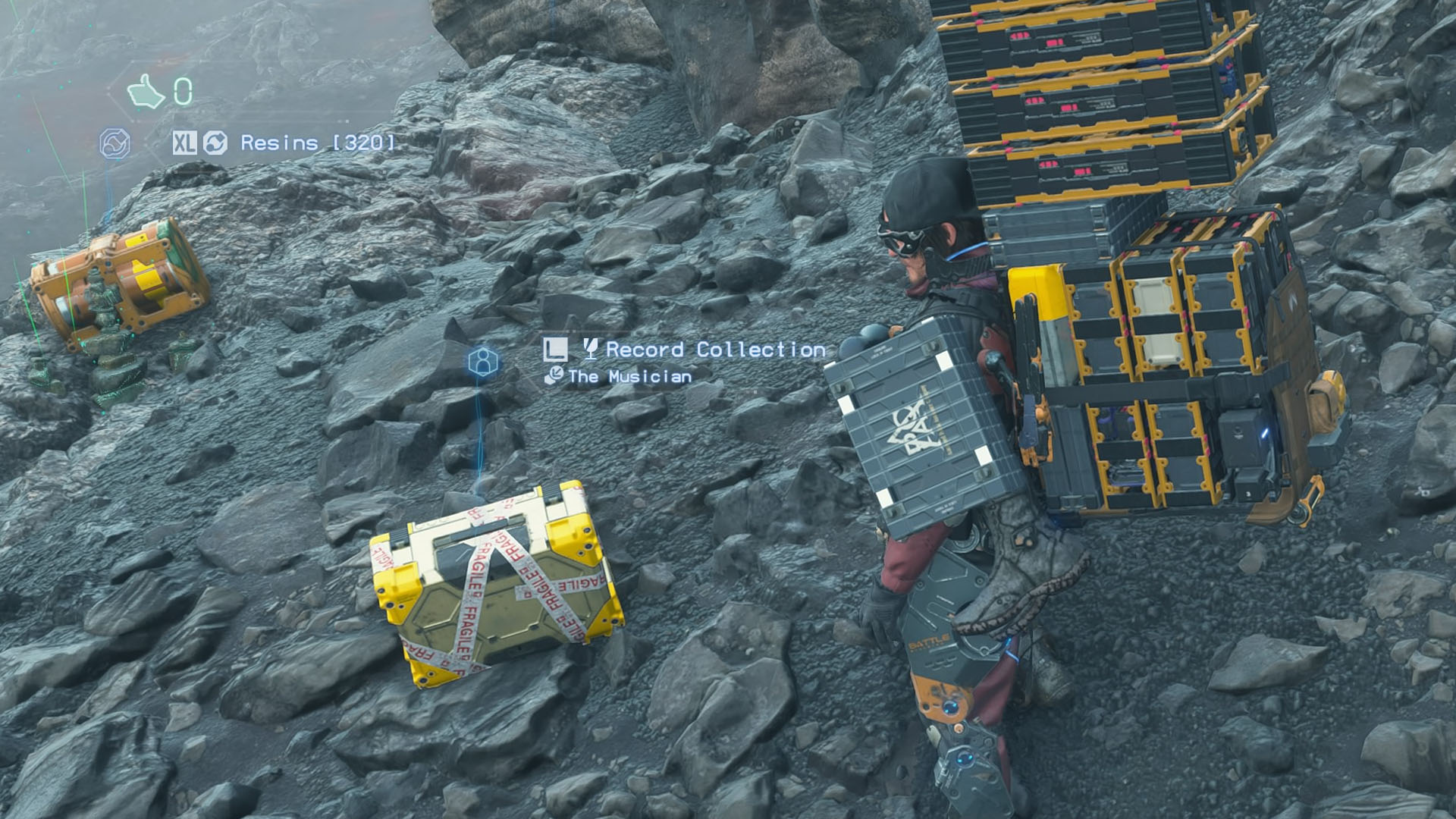 A Death Stranding 2 screenshot showing the main character Sam Porter in front of the a box indicated as “Record Collection”. A Death Stranding 2 screenshot showing the main character Sam Porter in front of the a box indicated as “Record Collection”.