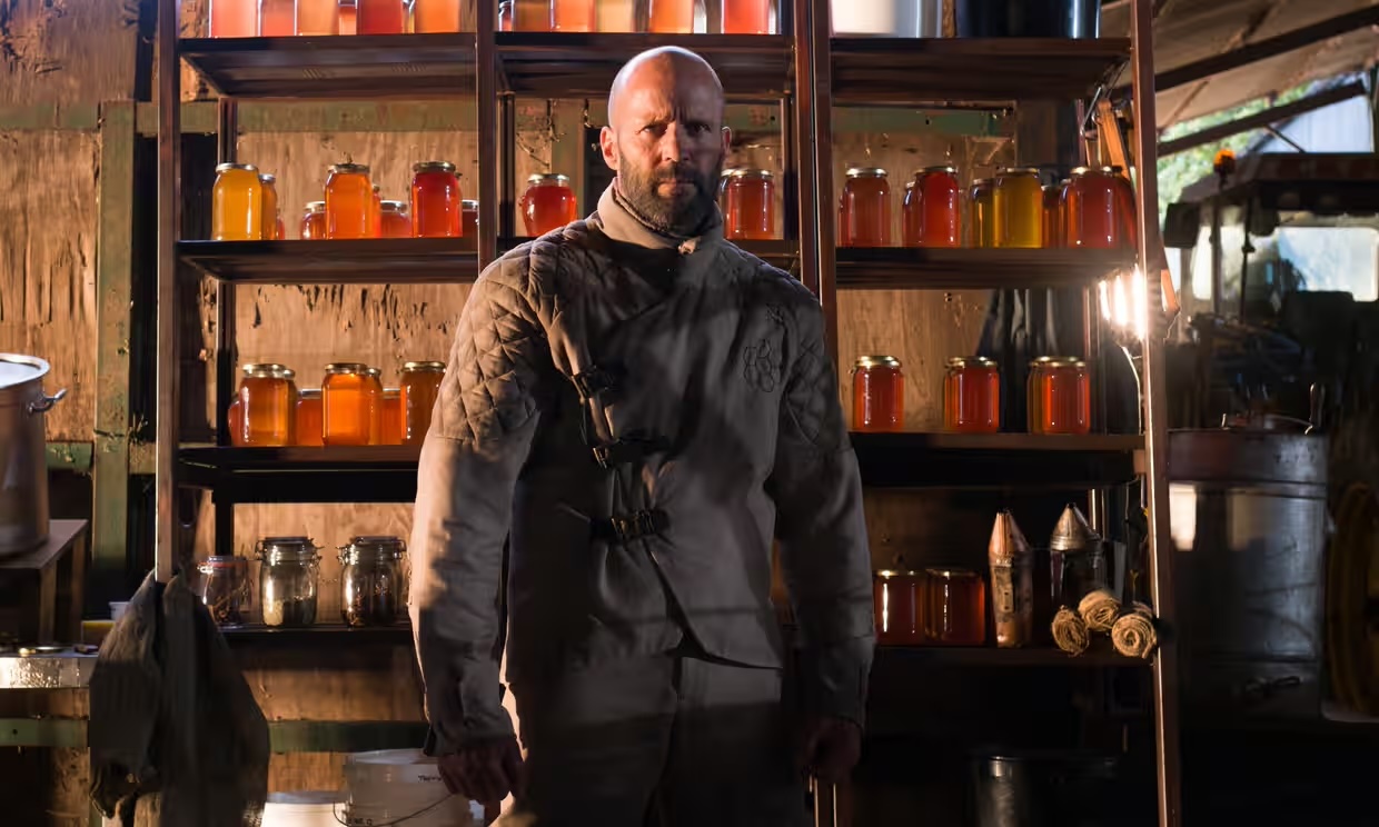 A beekeeper (Jason Statham) stands in front of some honey in The Beekeeper A beekeeper (Jason Statham) stands in front of some honey in The Beekeeper