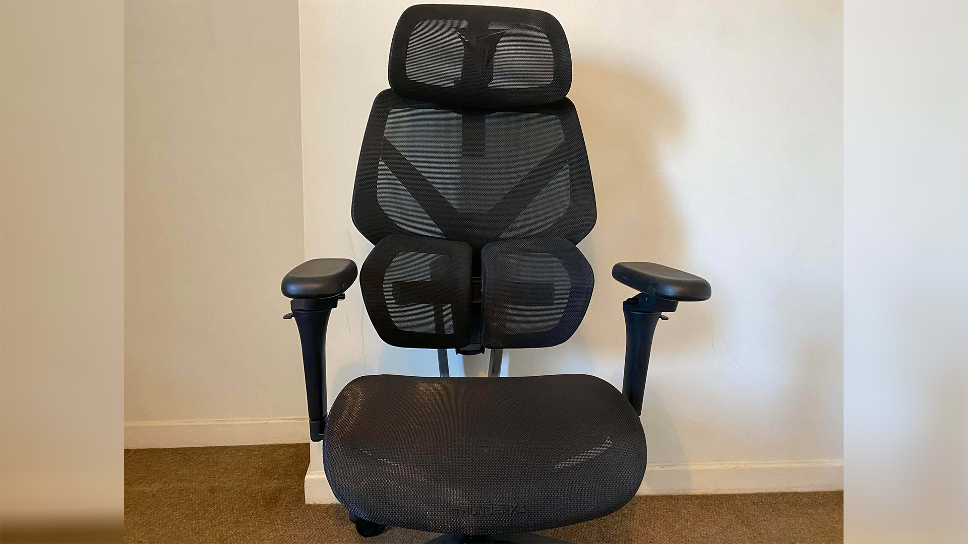 ThunderX3 chair set up in front of a white wall.