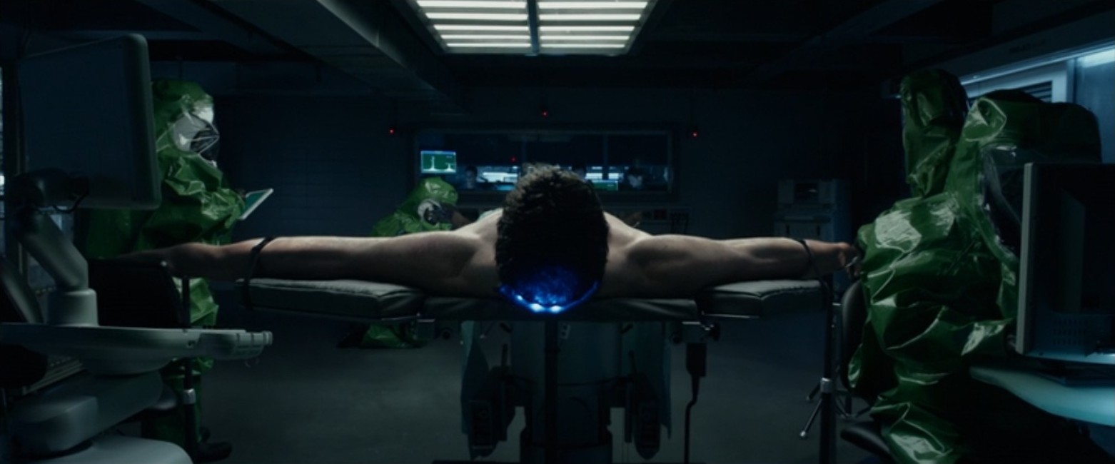 Reed Richards, played by Miles Teller, is strapped to a table with his arms stretched in a scene from the 2015 Fantastic Four movie. Reed Richards, played by Miles Teller, is strapped to a table with his arms stretched in a scene from the 2015 Fantastic Four movie.