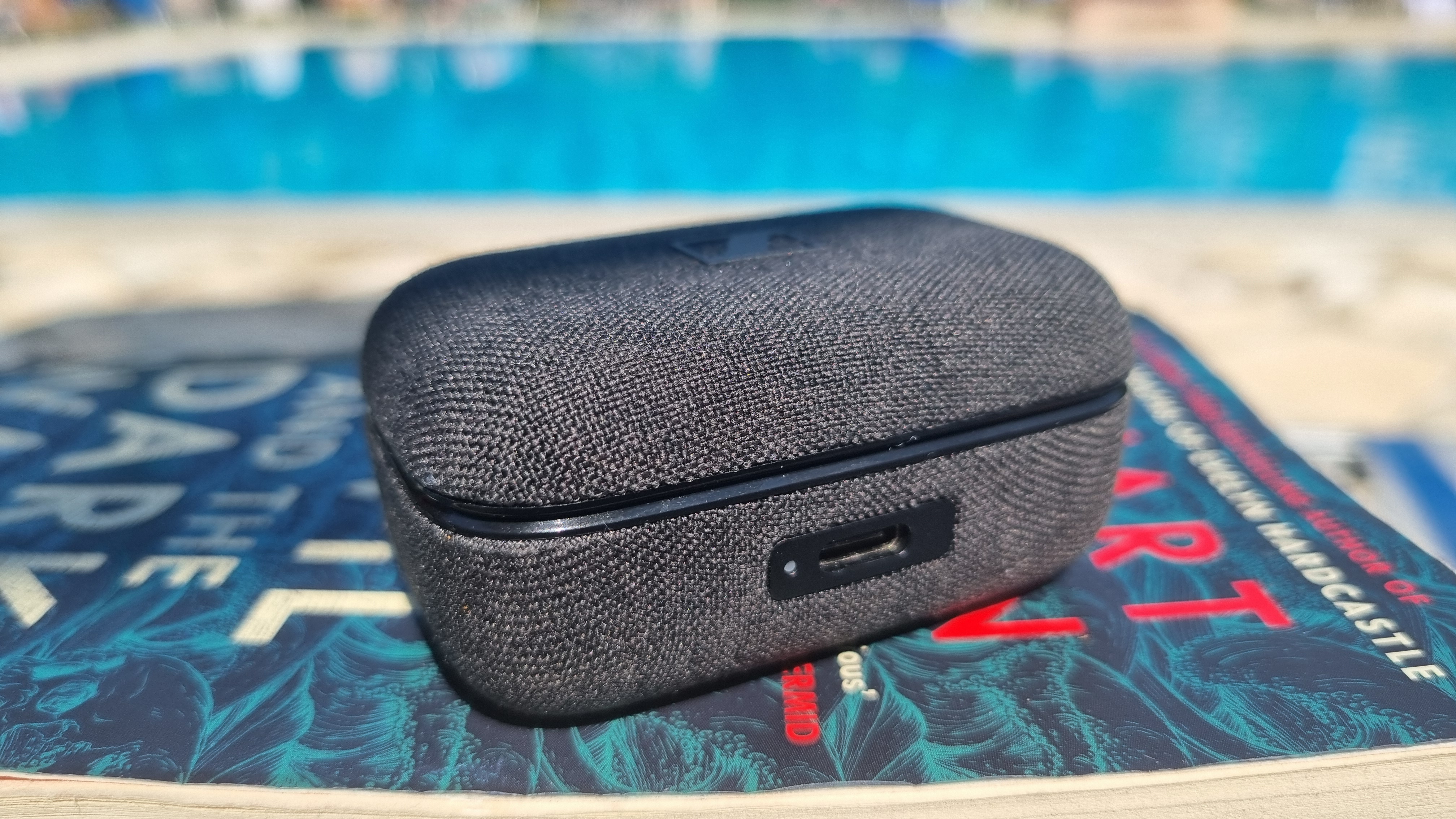 The Sennheiser Momentum True Wireless 4 earbuds case, on a book