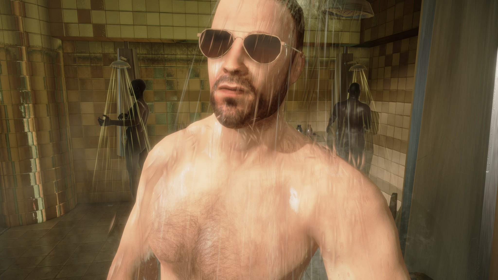 A man with sunglasses looks into the camera while standing in a shower full of other similarly naked people.
