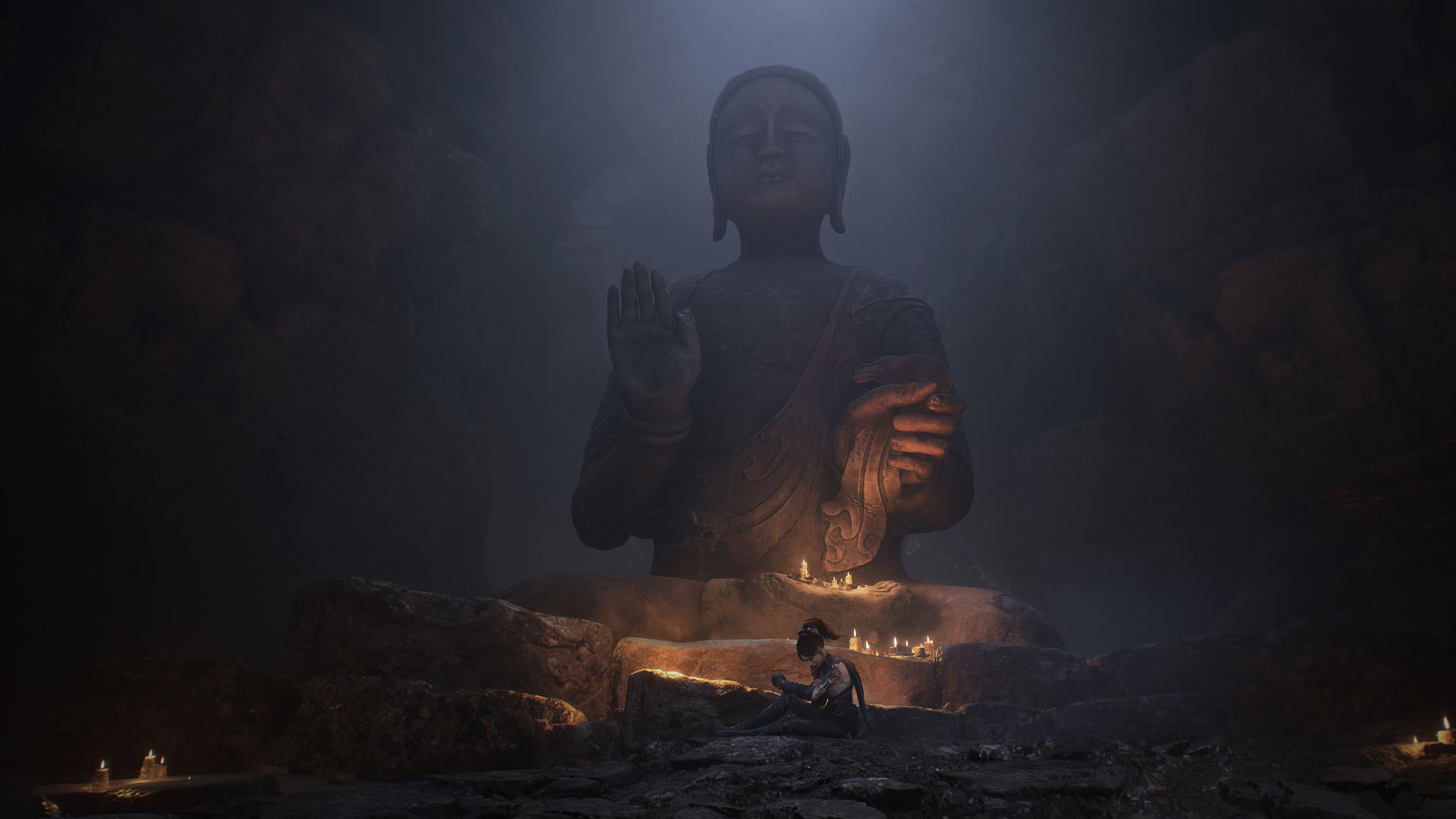 A Wuchang: Fallen Feathers screenshot showing the main character sit in front of a large Buddha statue.