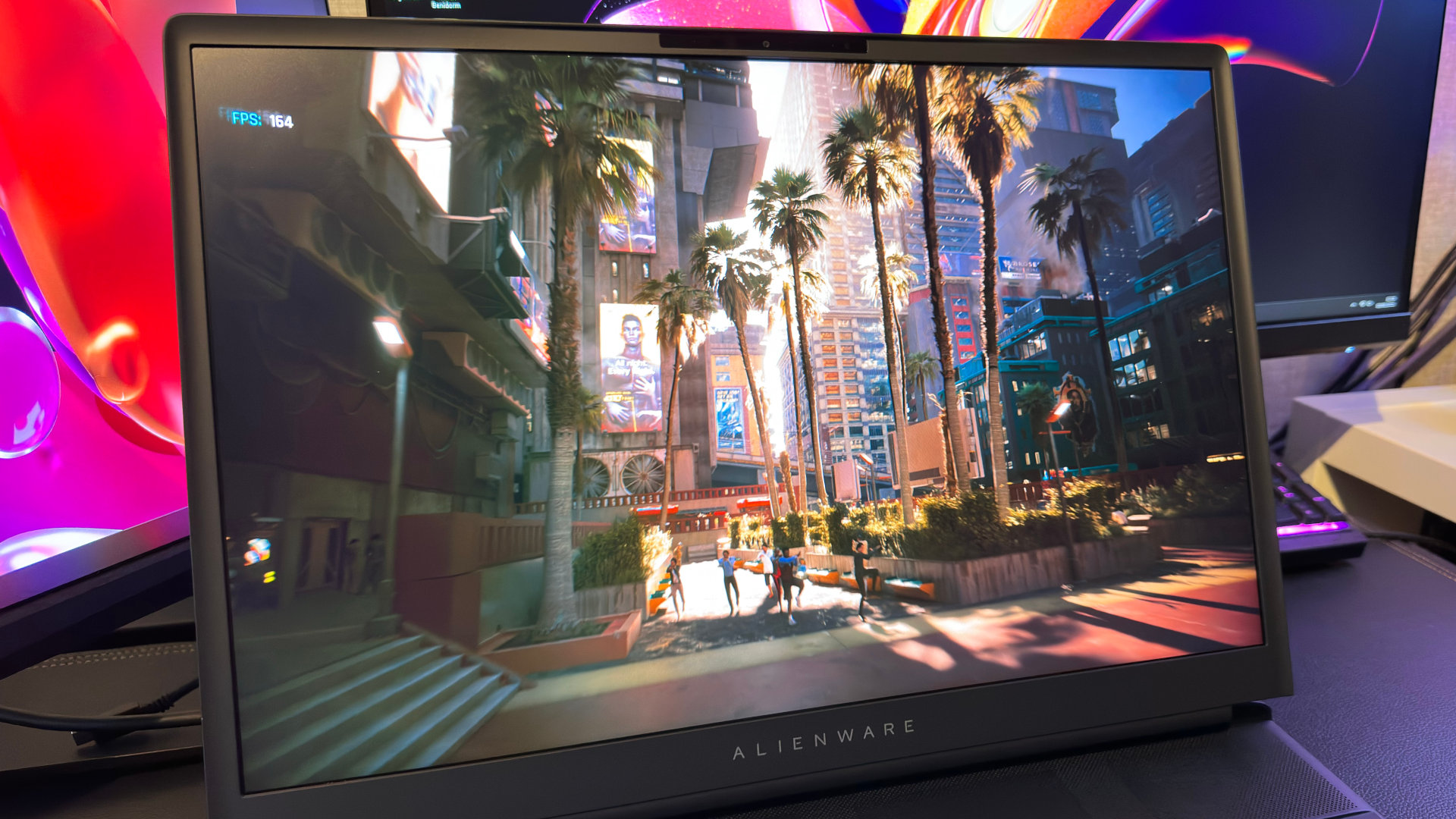 A close-up photo of the display of the Alienware 18 Area-51 gaming laptop, showing a screenshot of the Cyberpunk 2077 benchmark
