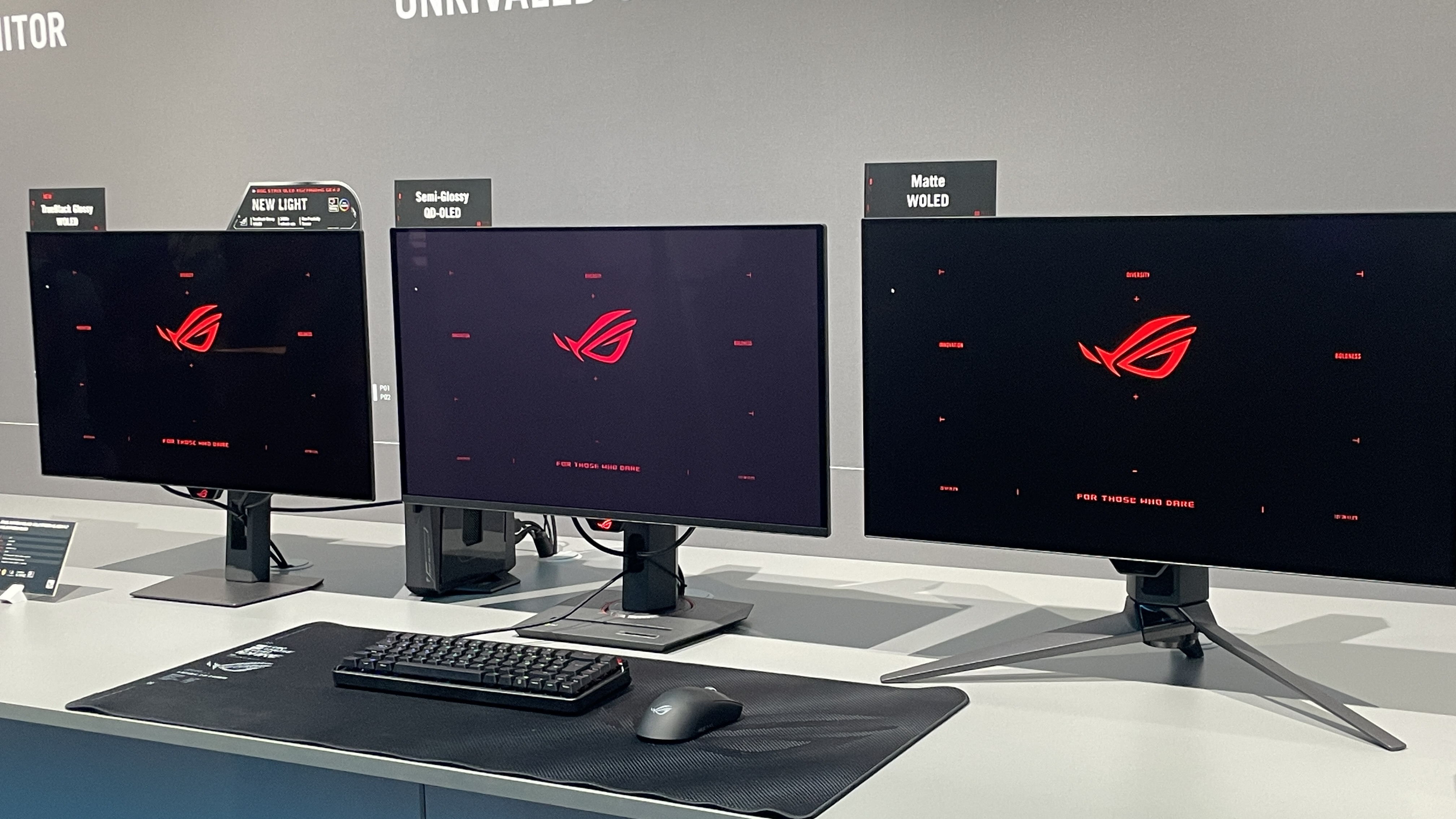 Three Asus ROG OLED monitors, showing the difference between TrueBlack Glossy and other coatings