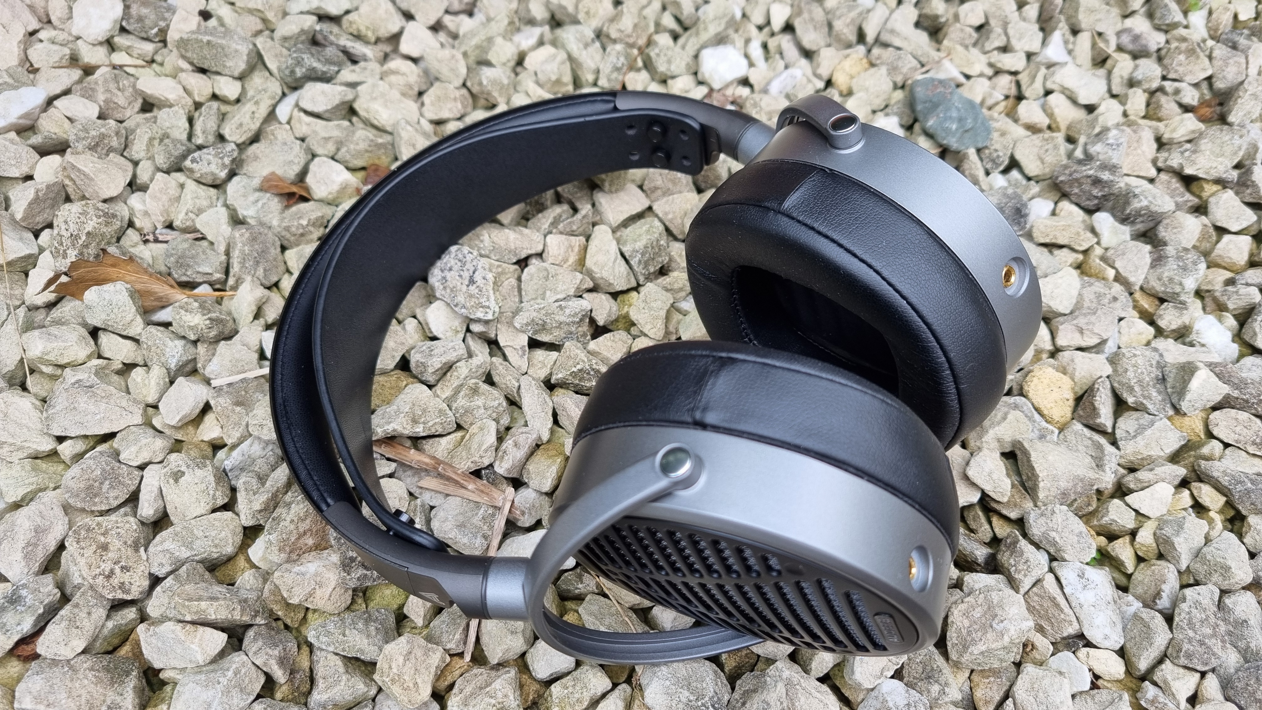 The Audeze MM-100 headphones on a gravel background
