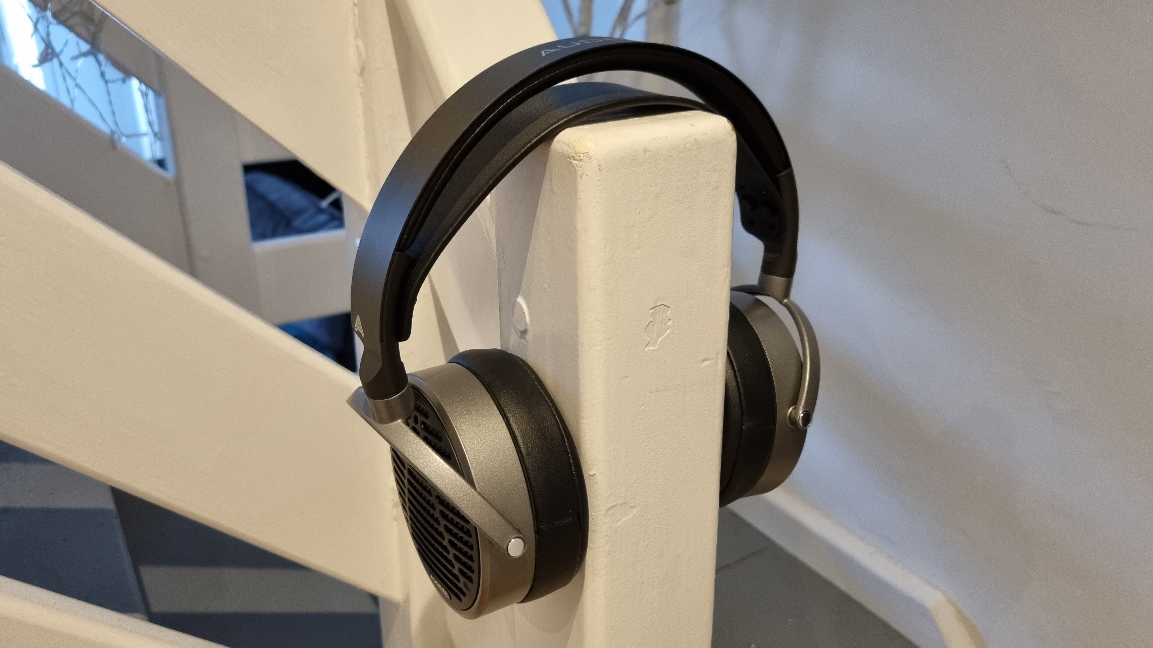 The Audeze MM-100 over a stair bannister, as if being worn