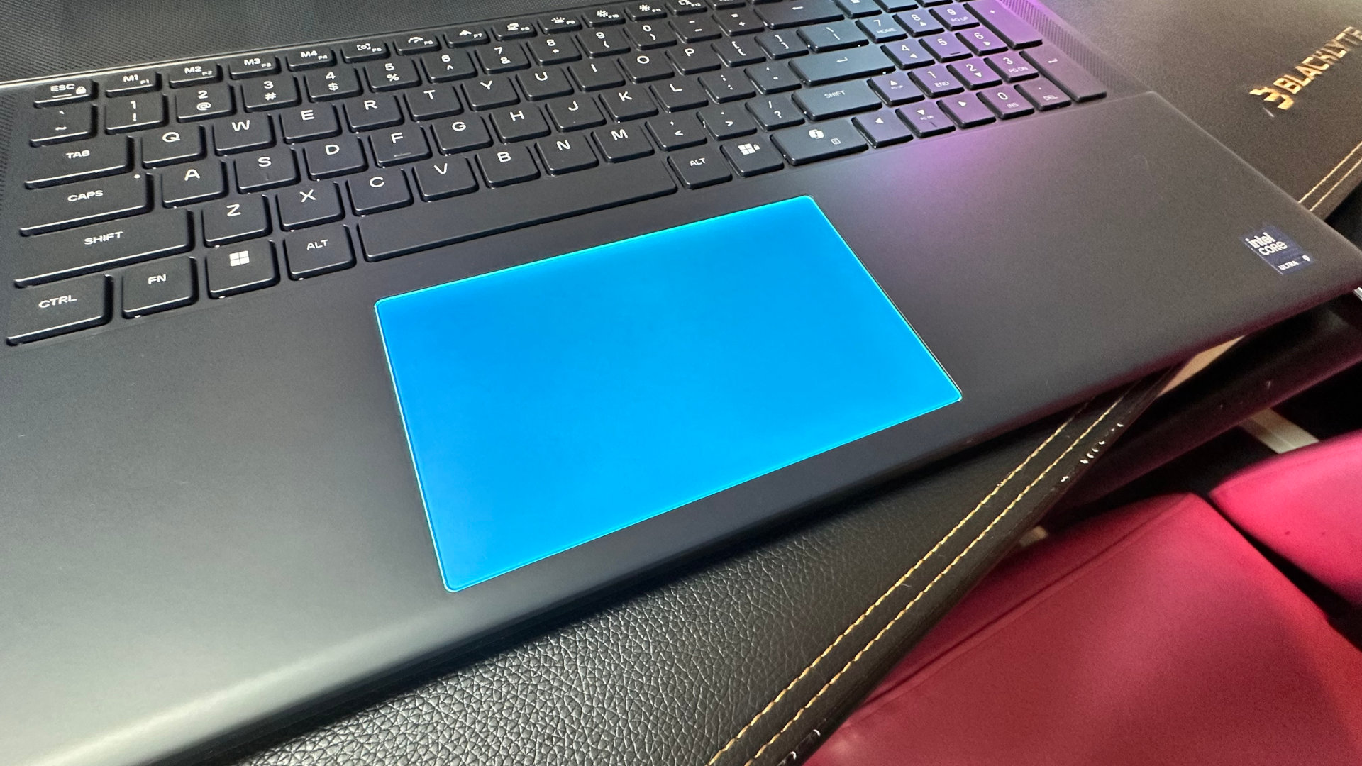 A close-up photo of the trackpad of the Alienware 18 Area-51 gaming laptop, fully illuminated with its built-in RGB lights