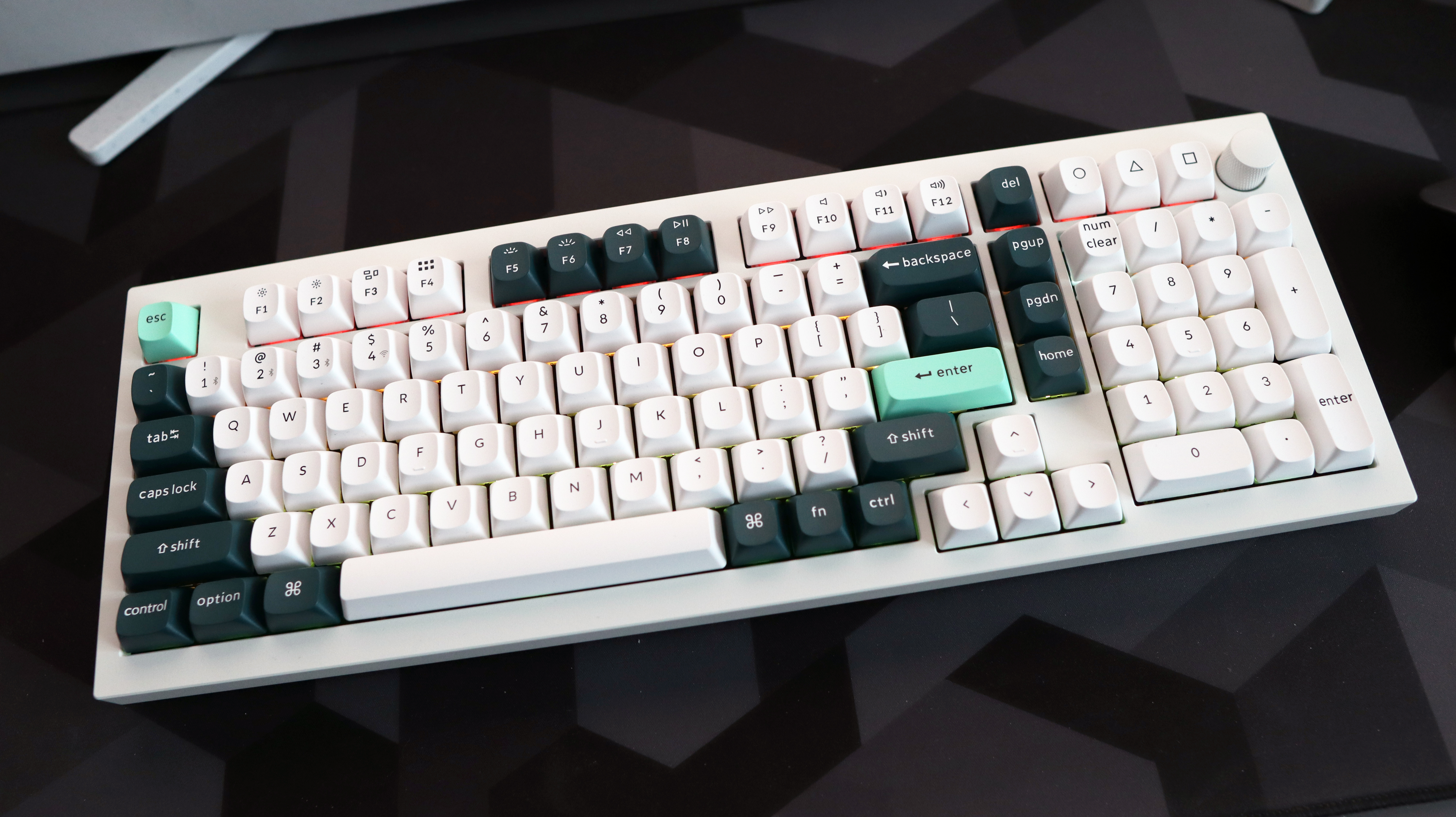 A Keychron Q5 HE gaming keyboard on a desk with white and blue keycaps.