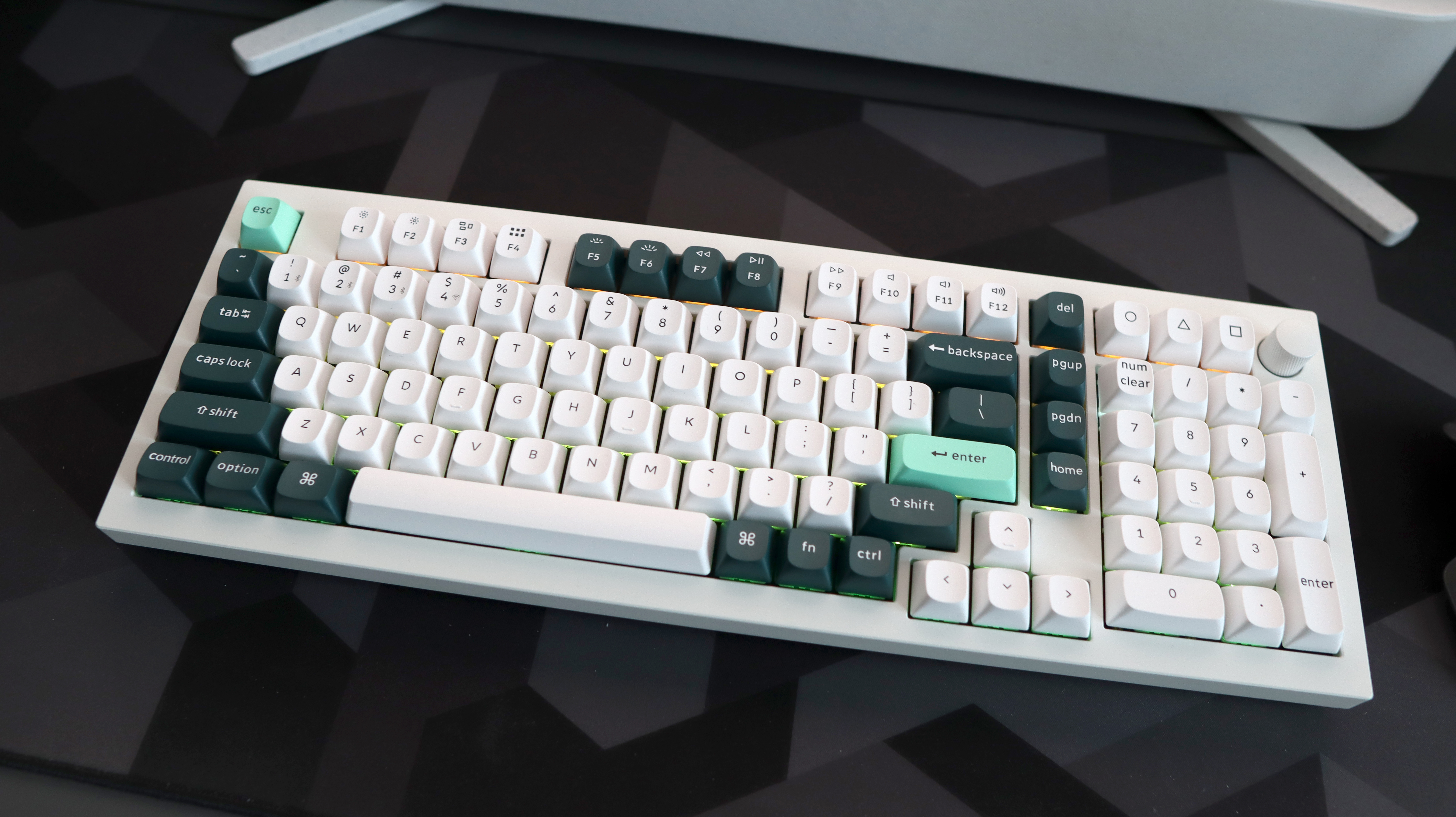 A Keychron Q5 HE gaming keyboard on a desk with white and blue keycaps.