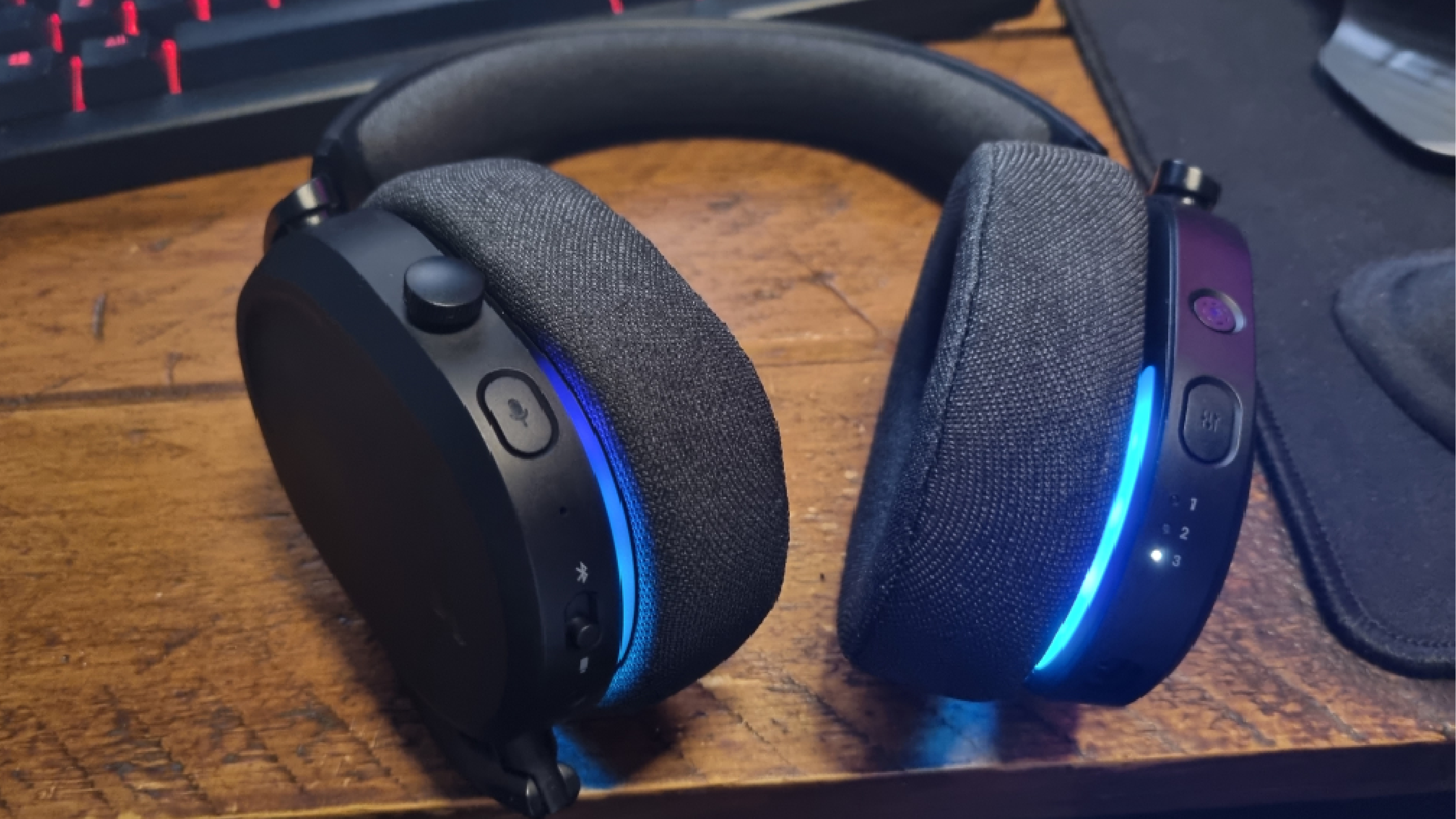 The rear earcup controls of the Fractal Scape, lit up in blue