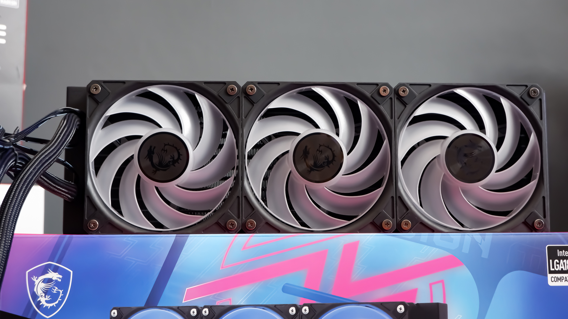 An MSI MPG CoreLiquid P13 all-in-one liquid cooler on a desk and installed onto a test bench for testing.