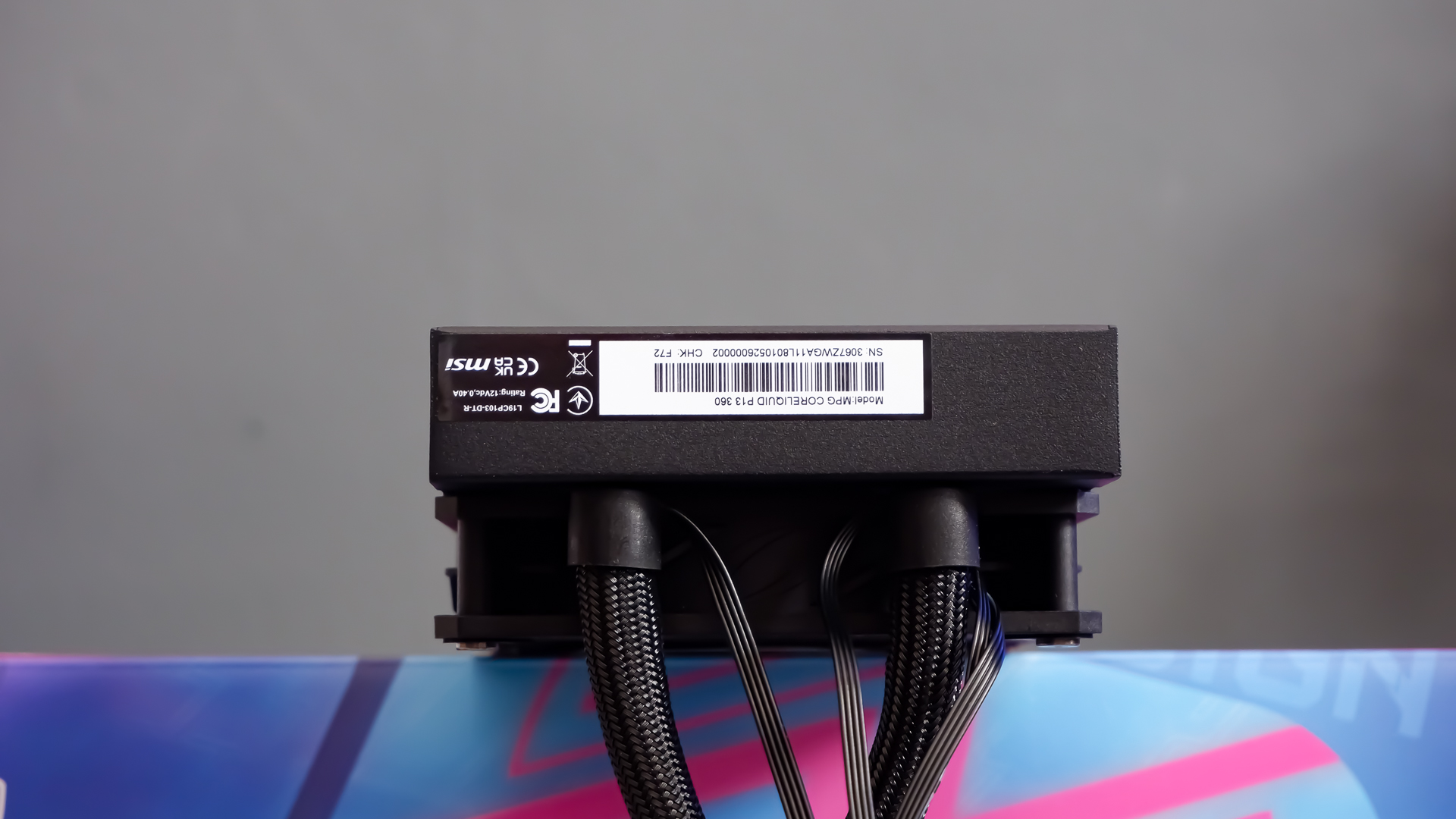 An MSI MPG CoreLiquid P13 all-in-one liquid cooler on a desk and installed onto a test bench for testing.