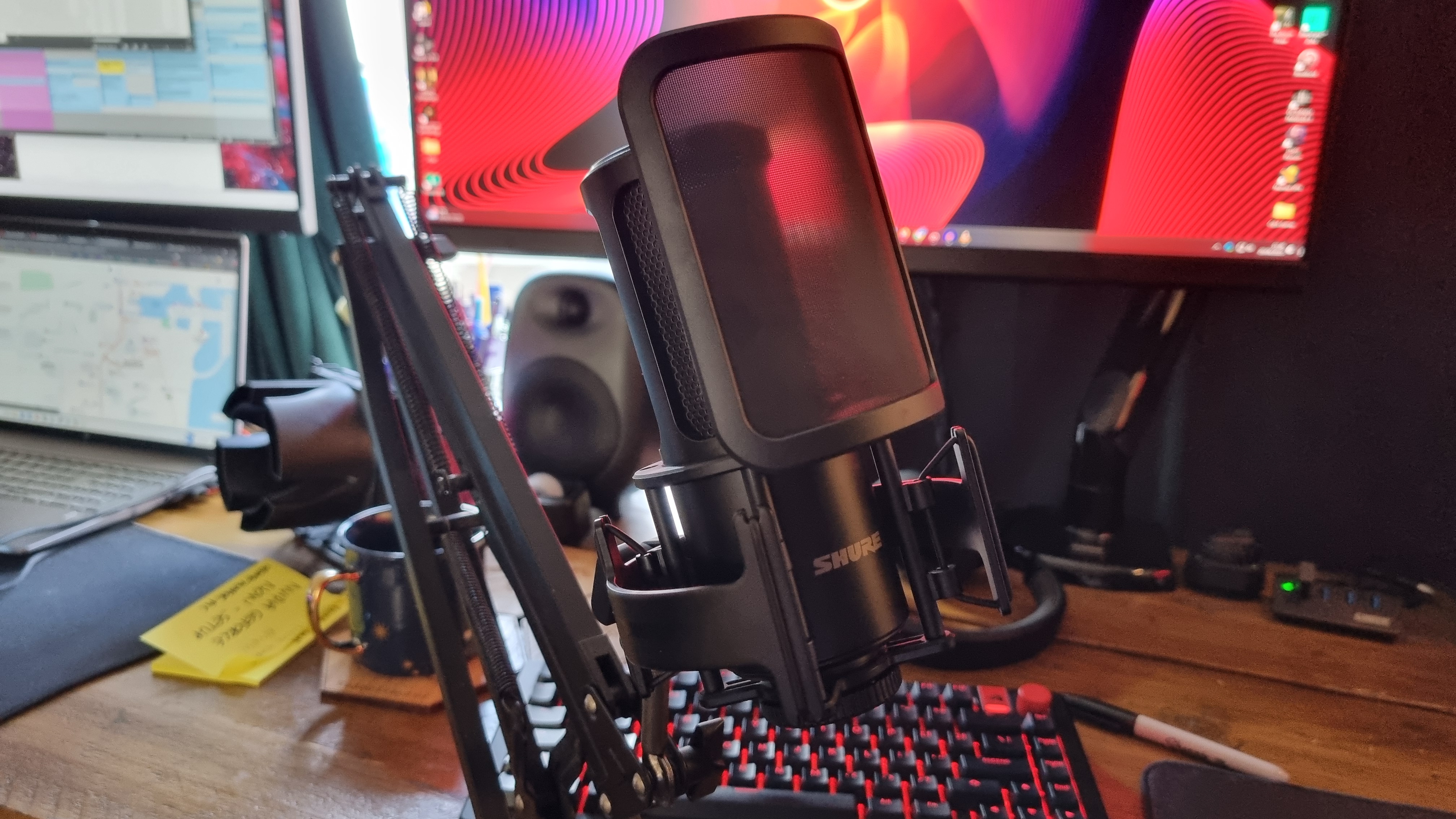 The Shure SM4 home recording microphone attached to a boom arm, with its magnetic pop filter attached