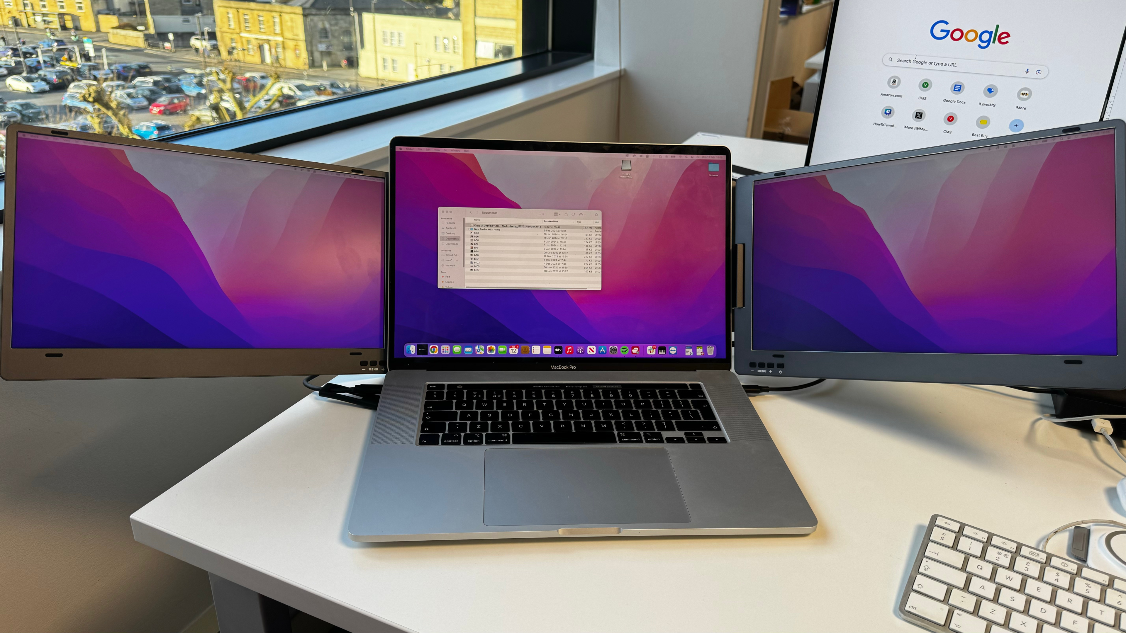 A photo of an Apple MacBook with additional screens attached to the main display