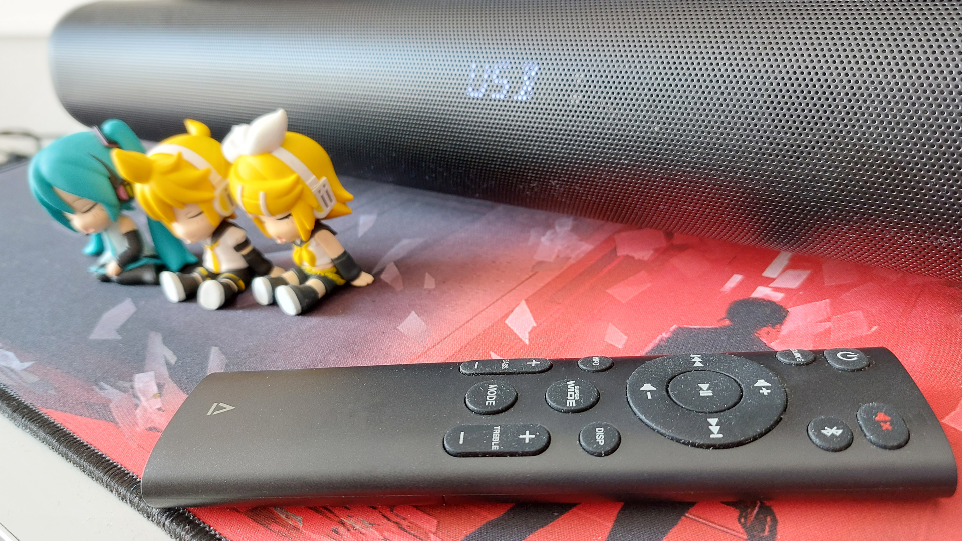 A close up of the Creative Stage Pro and the soundbar's remote.