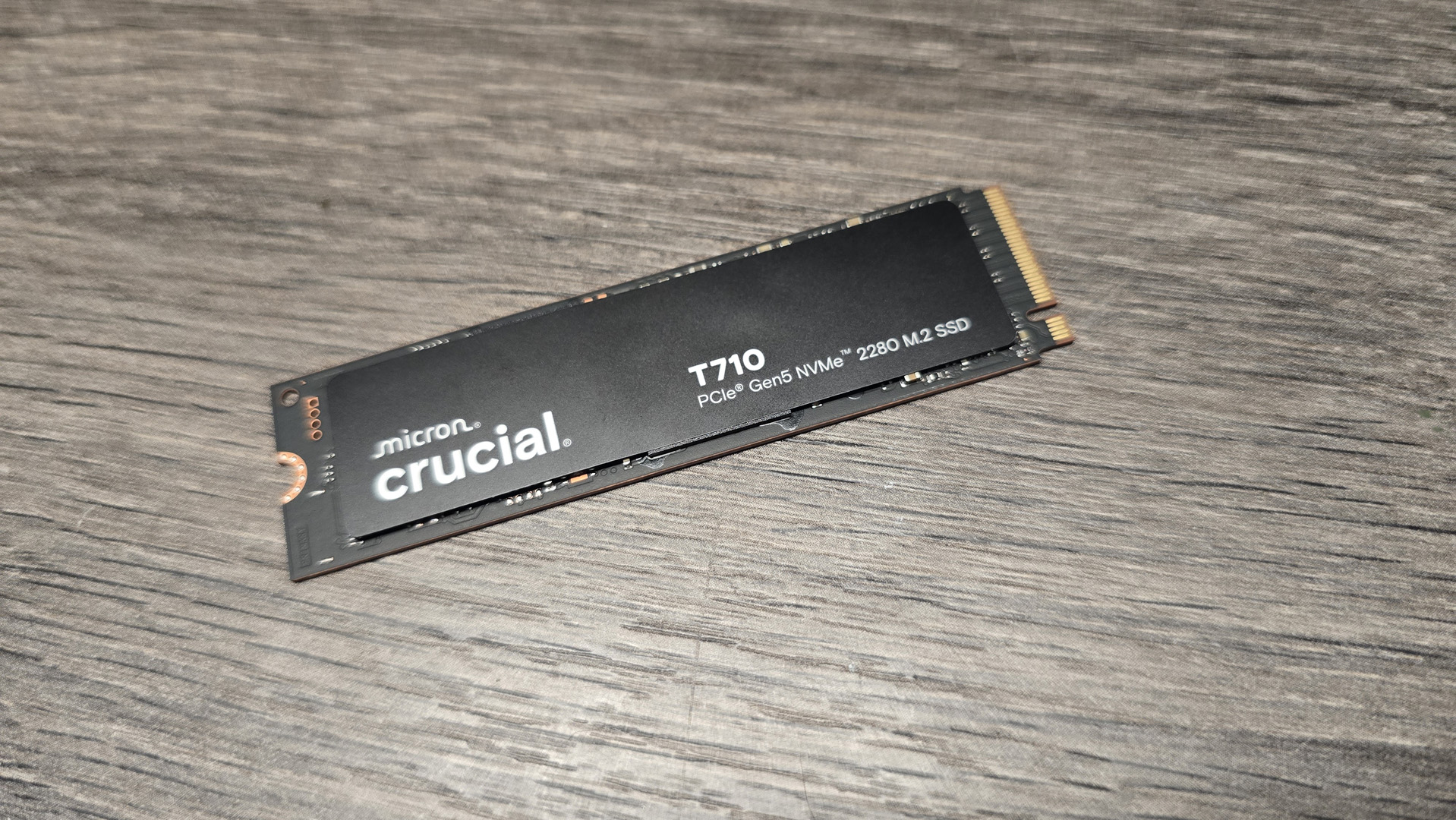 A Crucial T710 SSD on some fans ready to be installed inside a gaming PC.