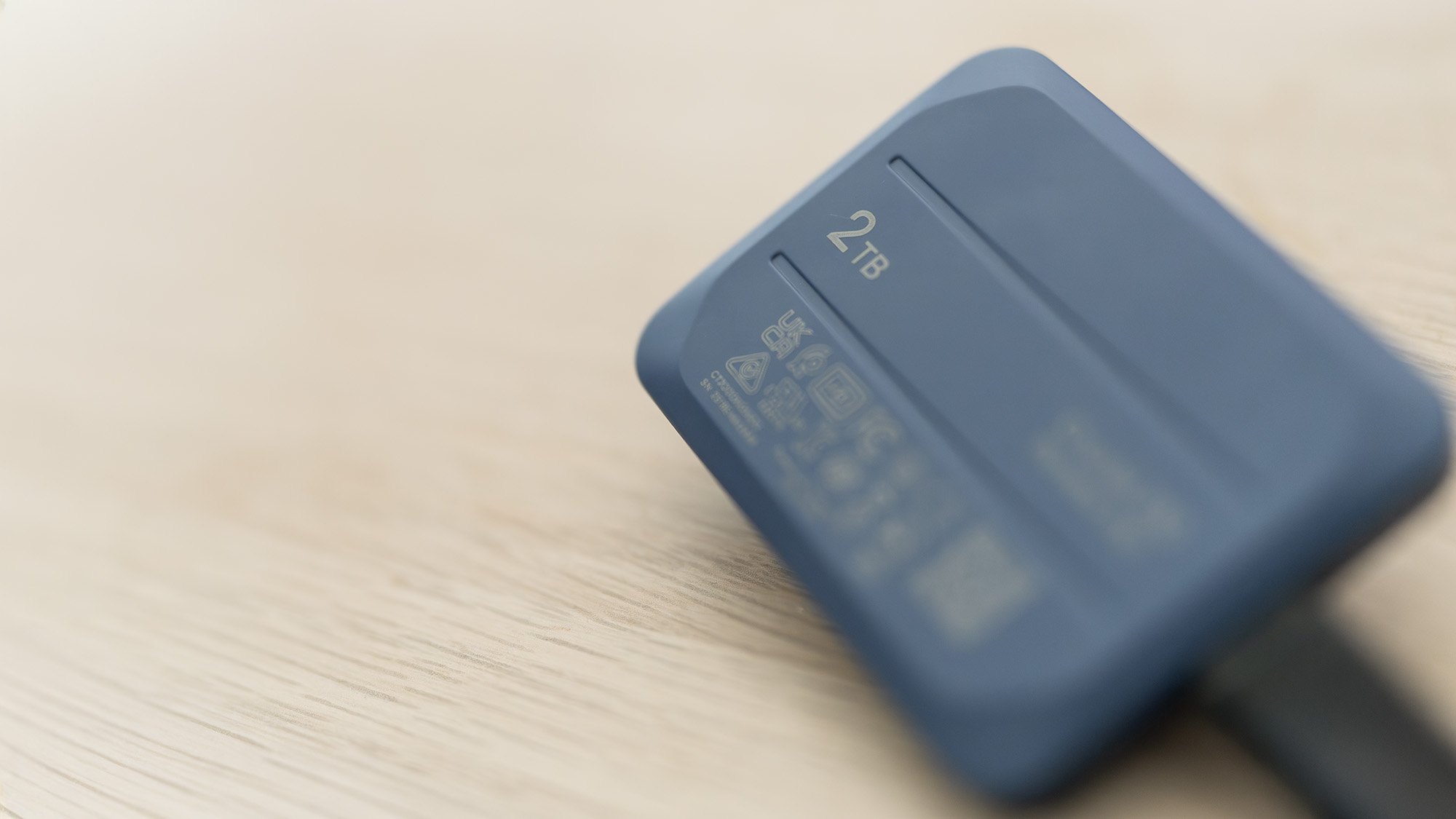 A Crucial X10 external SSD in blue with USB Type-C connector cable.