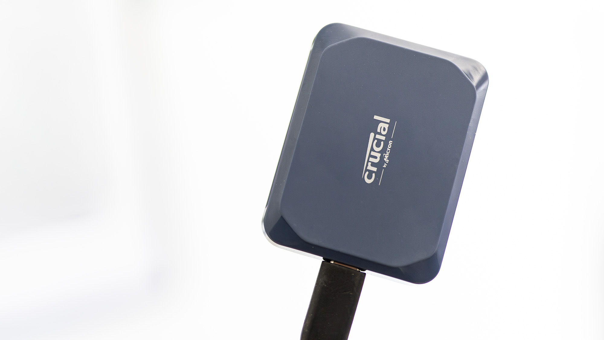 A Crucial X10 external SSD in blue with USB Type-C connector cable.