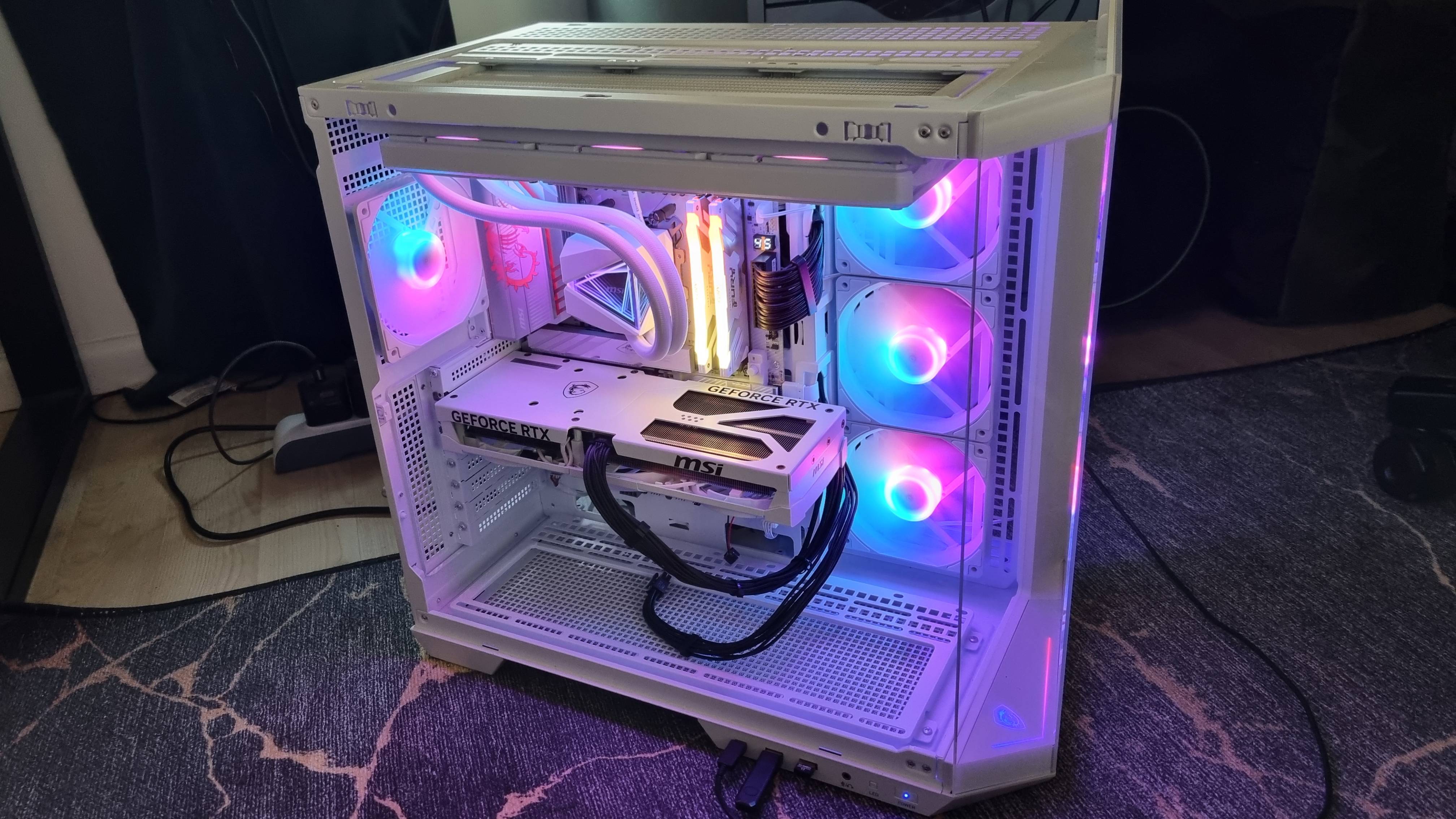 An MSI RTX 5080 test machine, used by PC Gamer for benchmarking, lit up in blue, pink, and purple