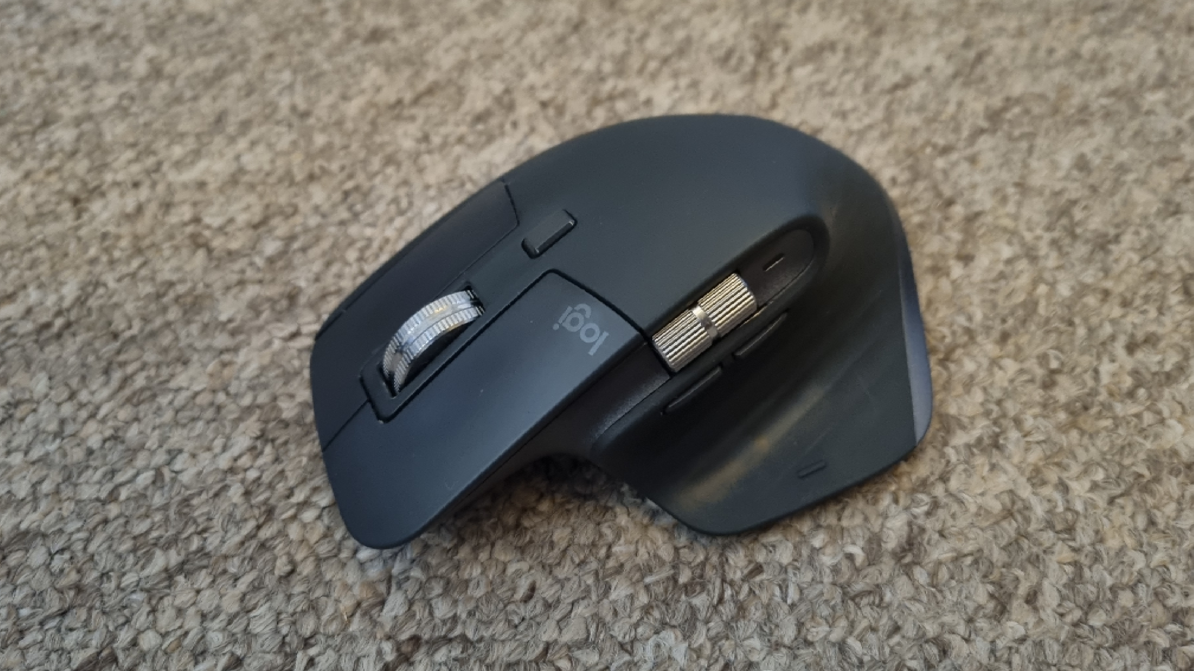 A Logitech MX Master 3S mouse on carpet, with natural lighting
