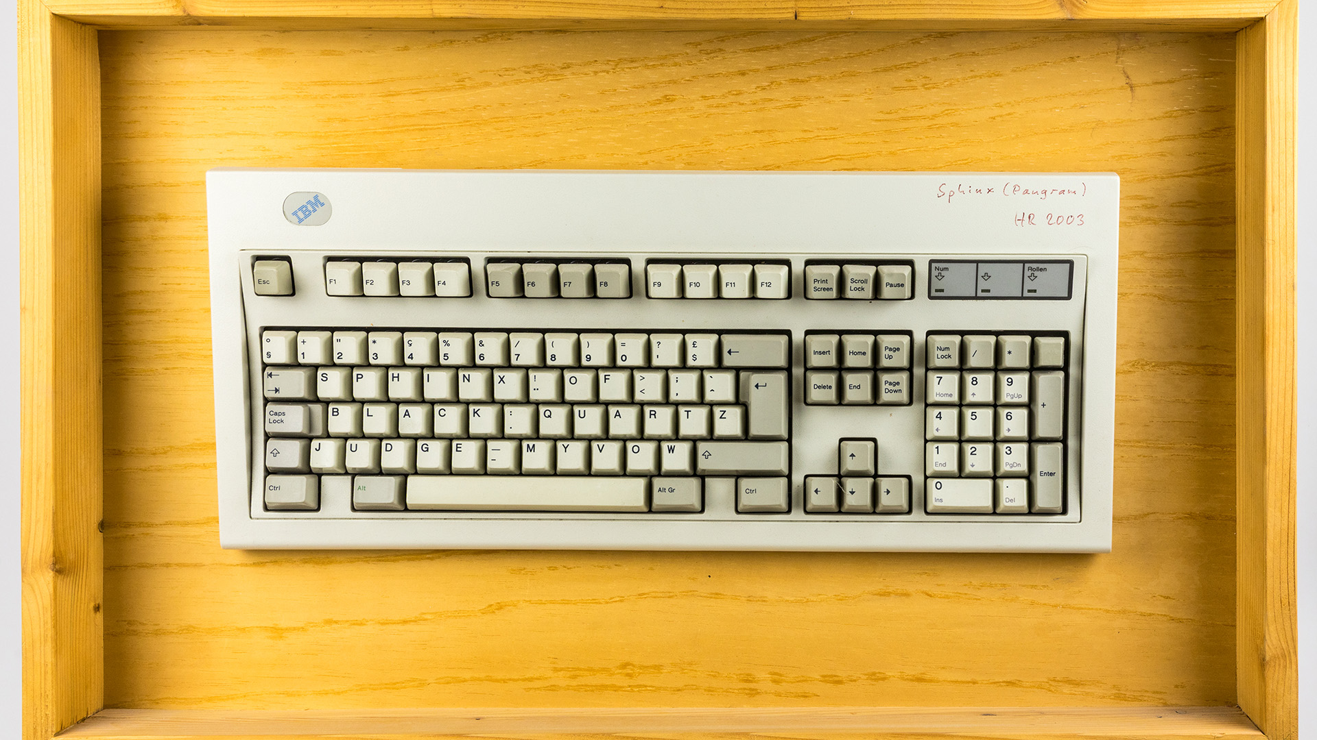 Cropped to 16:9: an IBM Model M keyboard on a wooden background.