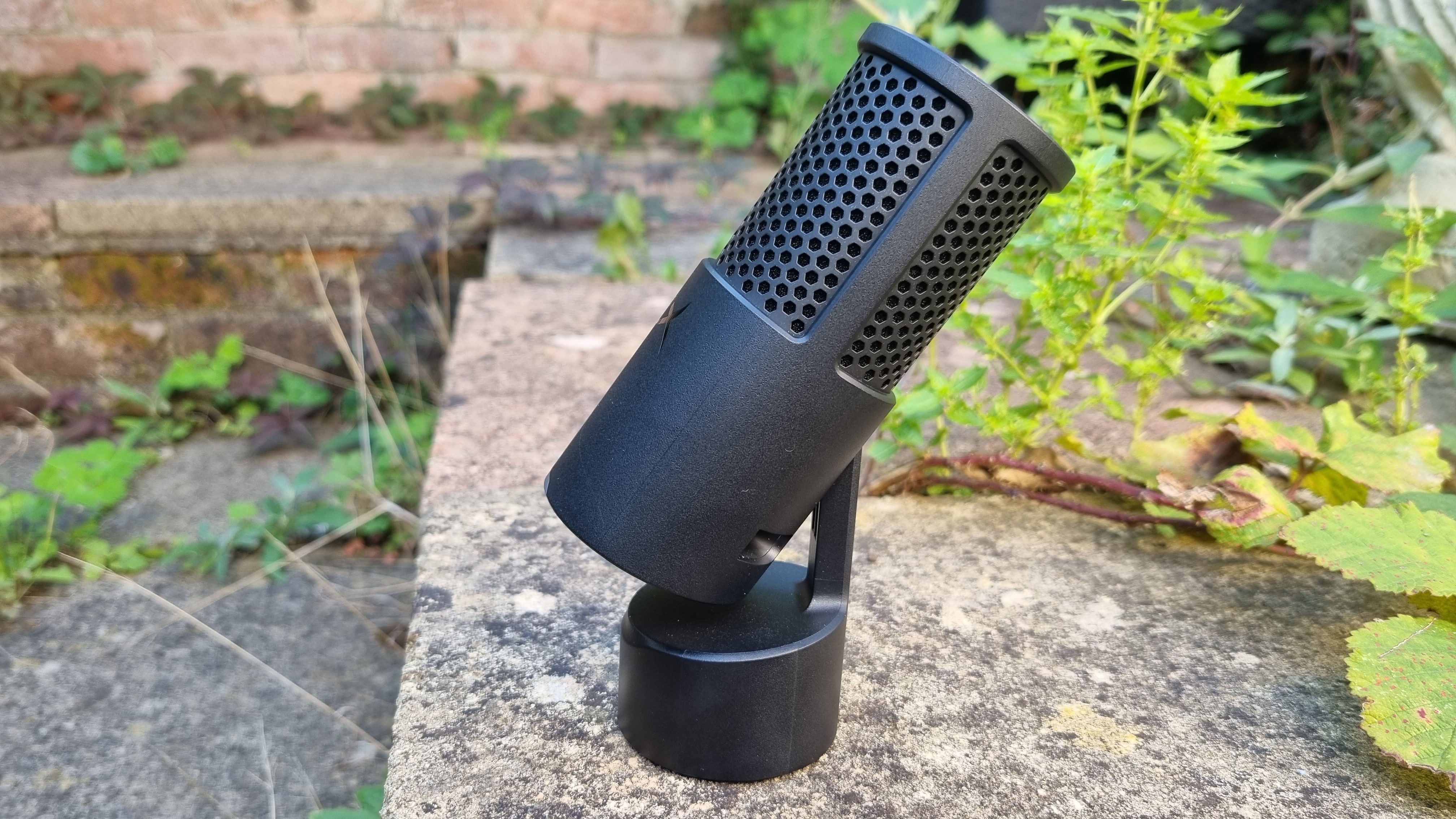 The HyperX Solocast 2 USB microphone shot from the side, with its stand deployed