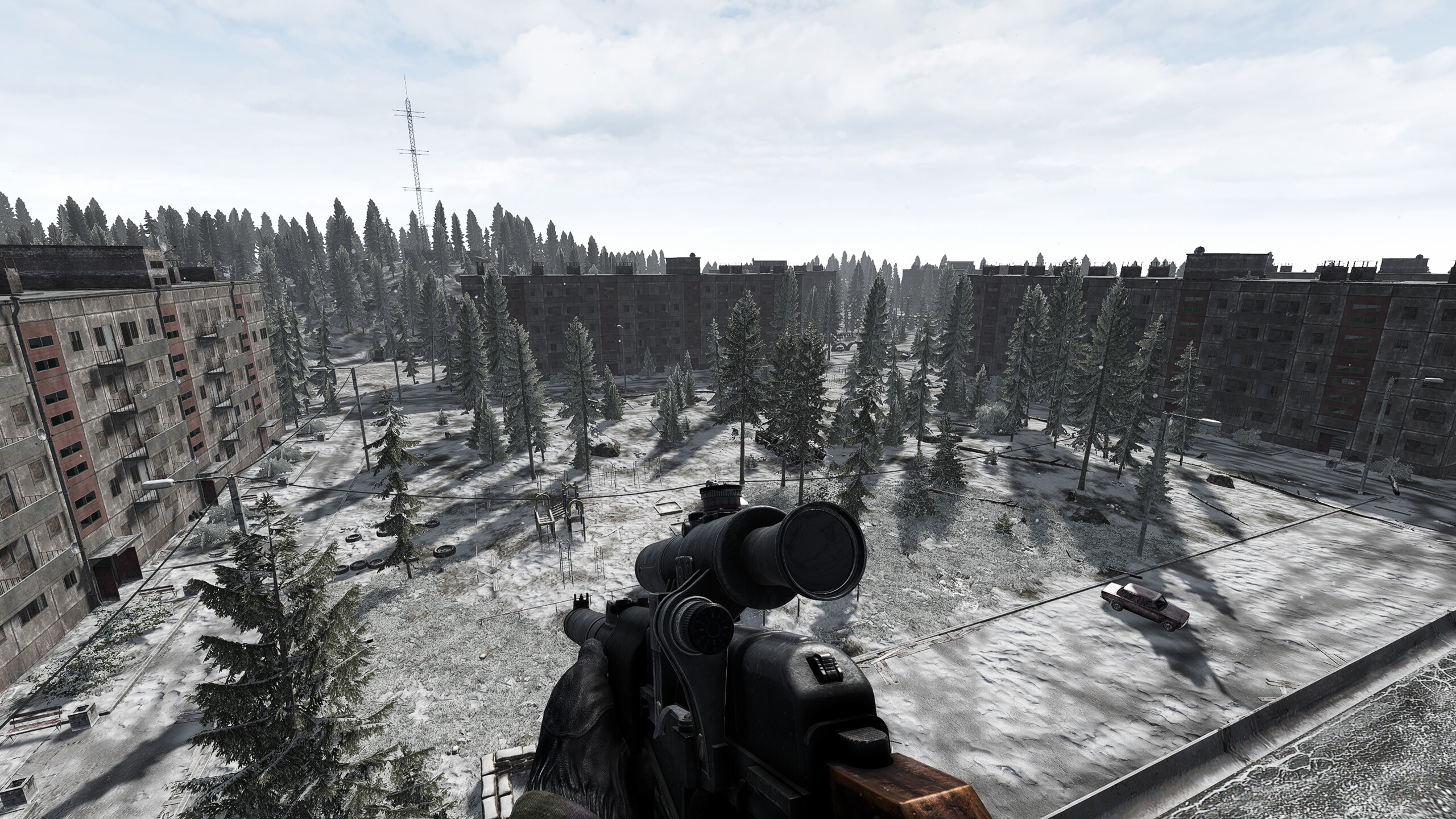 The player looks out across a wintery abandoned apartment bloc in Road to Vostok.