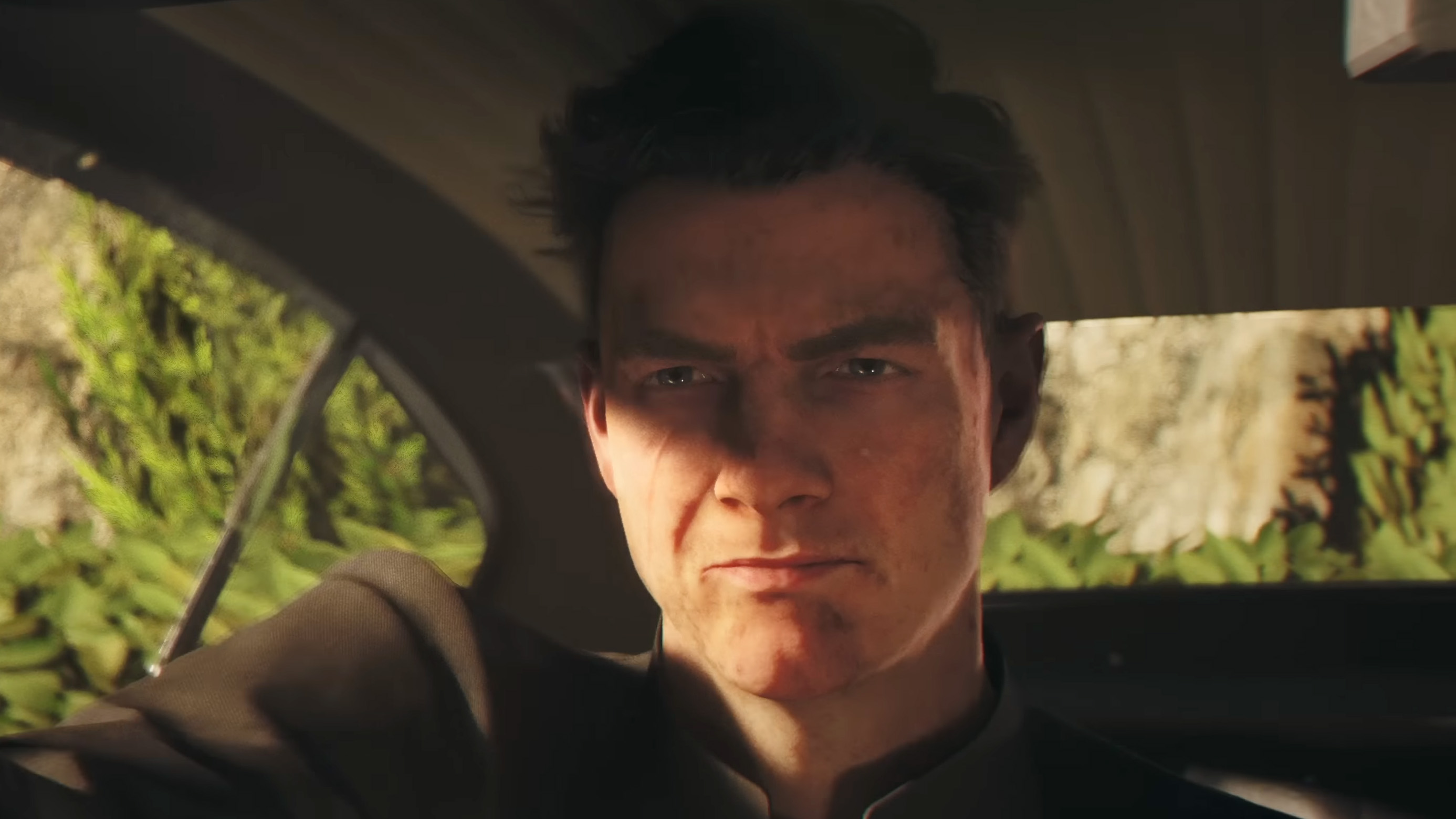 A young James Bond in 007 First Light furrowing his eyebrows. His face is dirty and he's in a car with a busted out window