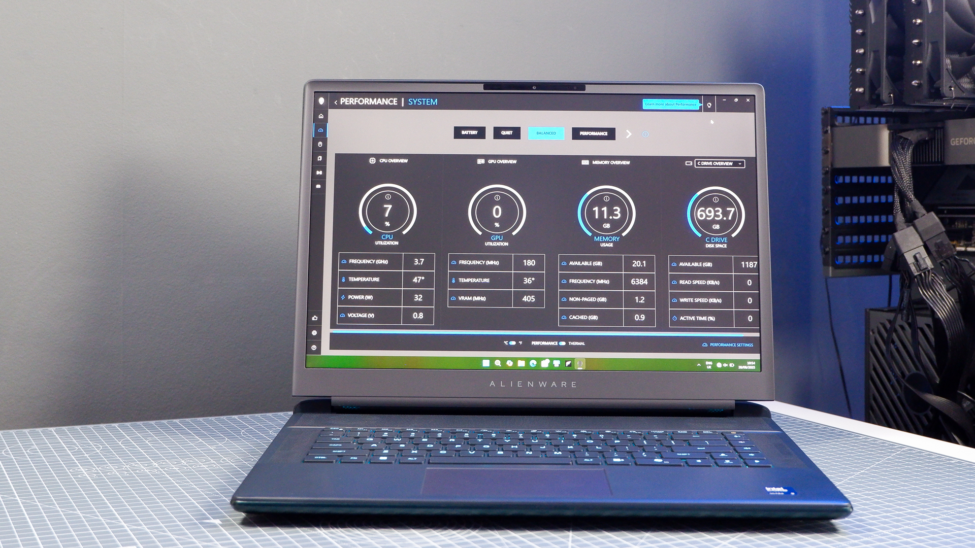 An Alienware 16 Area-51 gaming laptop with RGB lighting in blue on a desk mat.