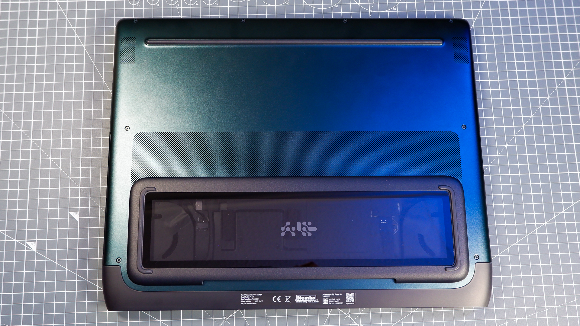 An Alienware 16 Area-51 gaming laptop with RGB lighting in blue on a desk mat.