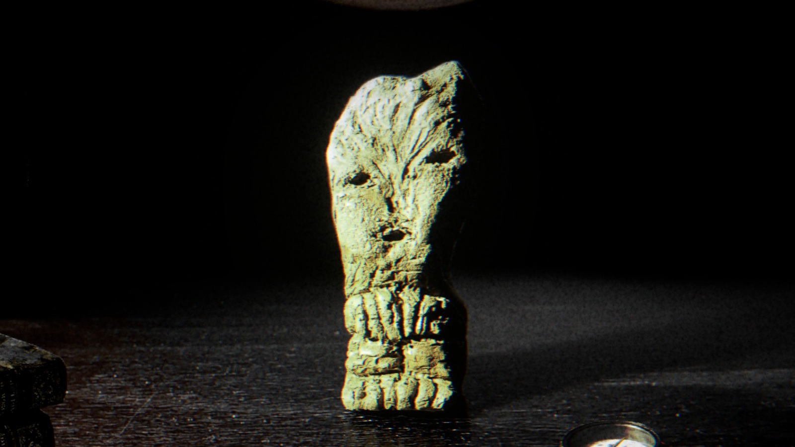 Close up view of the idol at the center of Children of Clay, a rough cut, disturbing thing with a misshapen human face