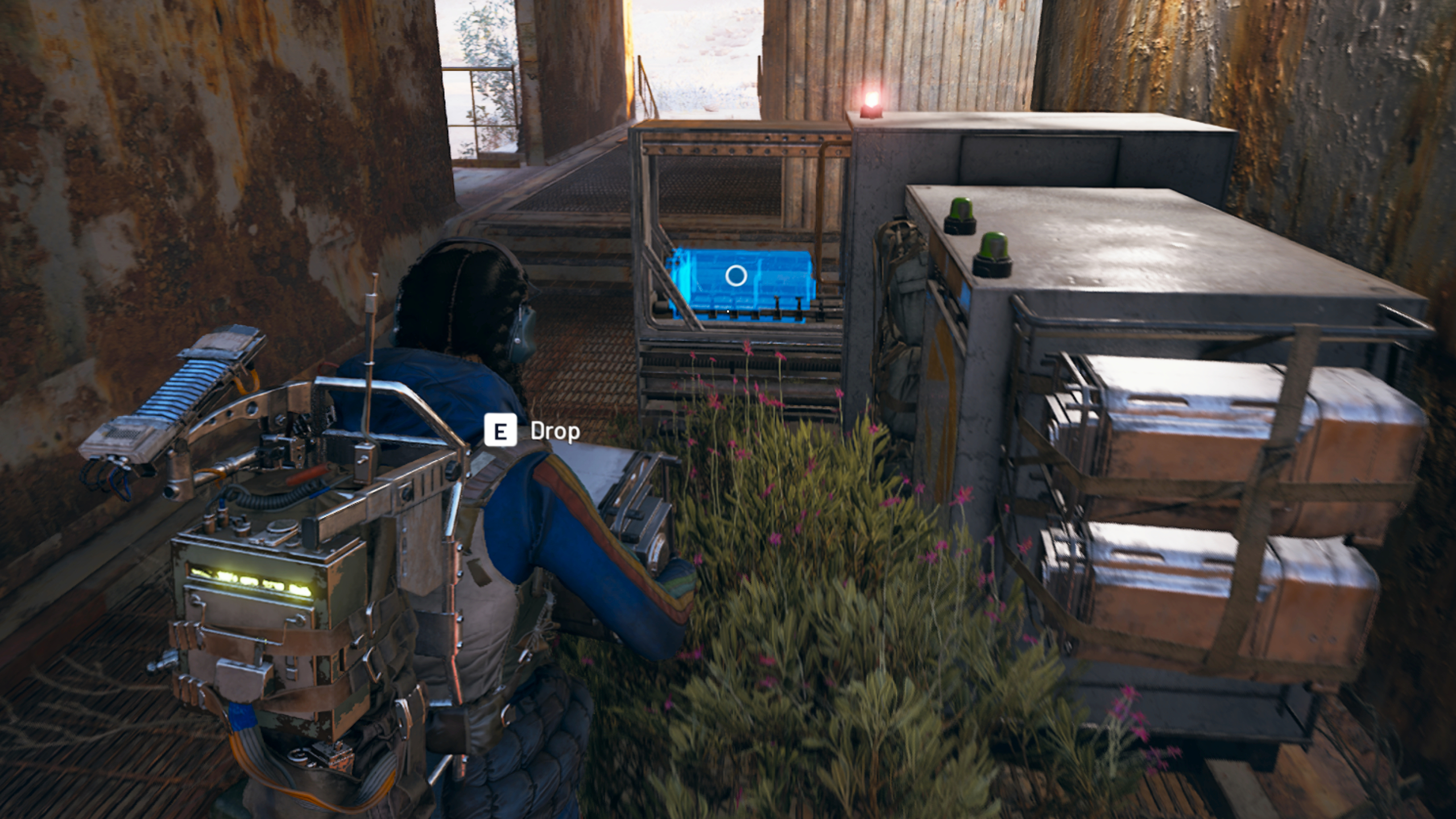 Arc Raiders: A raider wearing a blue jumpsuit and techy backpack carrying a heavy box towards a Field Depot drop-off point.